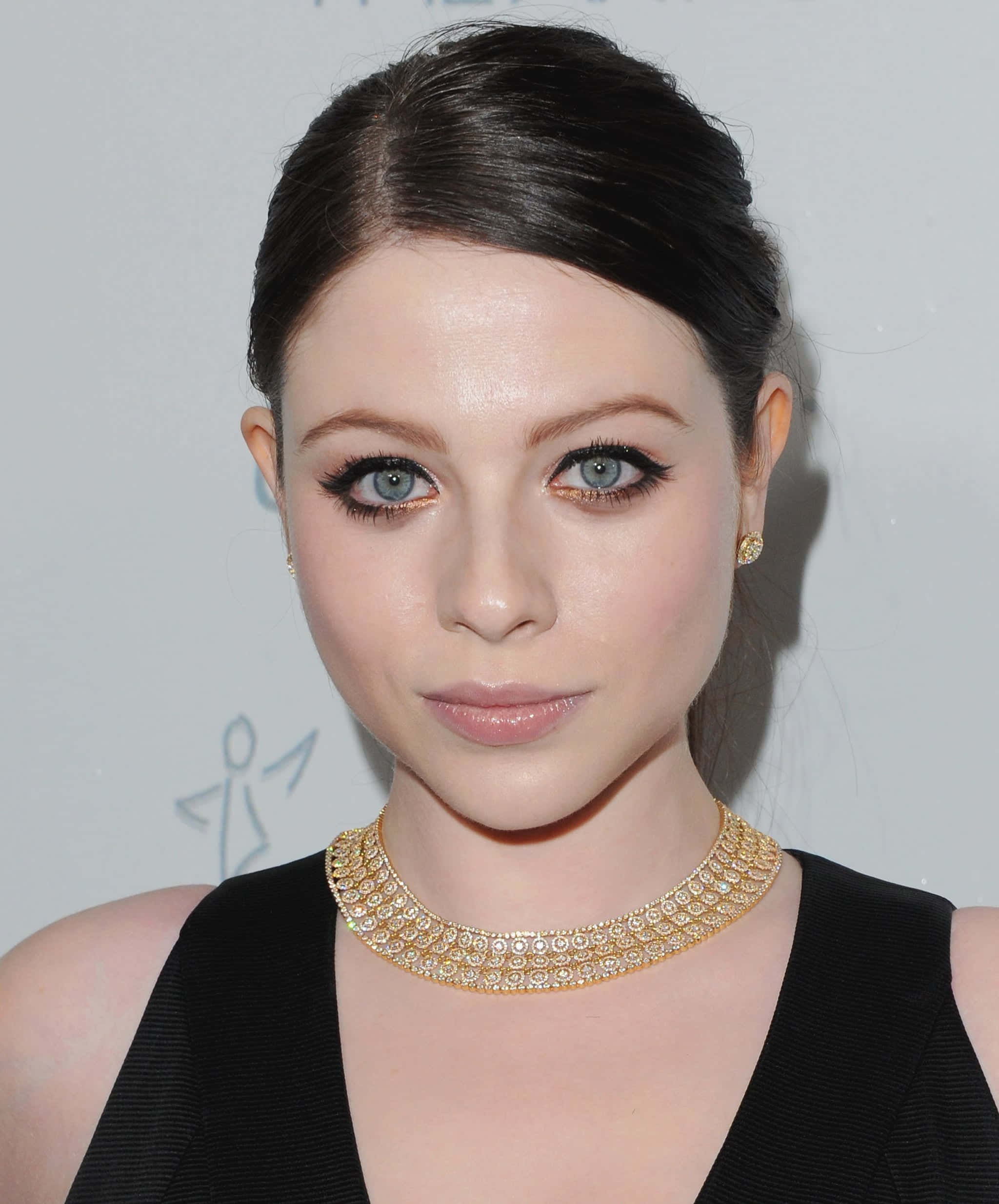michelle trachtenberg 桌布 壁紙 — 一位擁有引人注目藍眼睛的女子的特寫肖像，戴著金色頸鏈和黑色上衣。