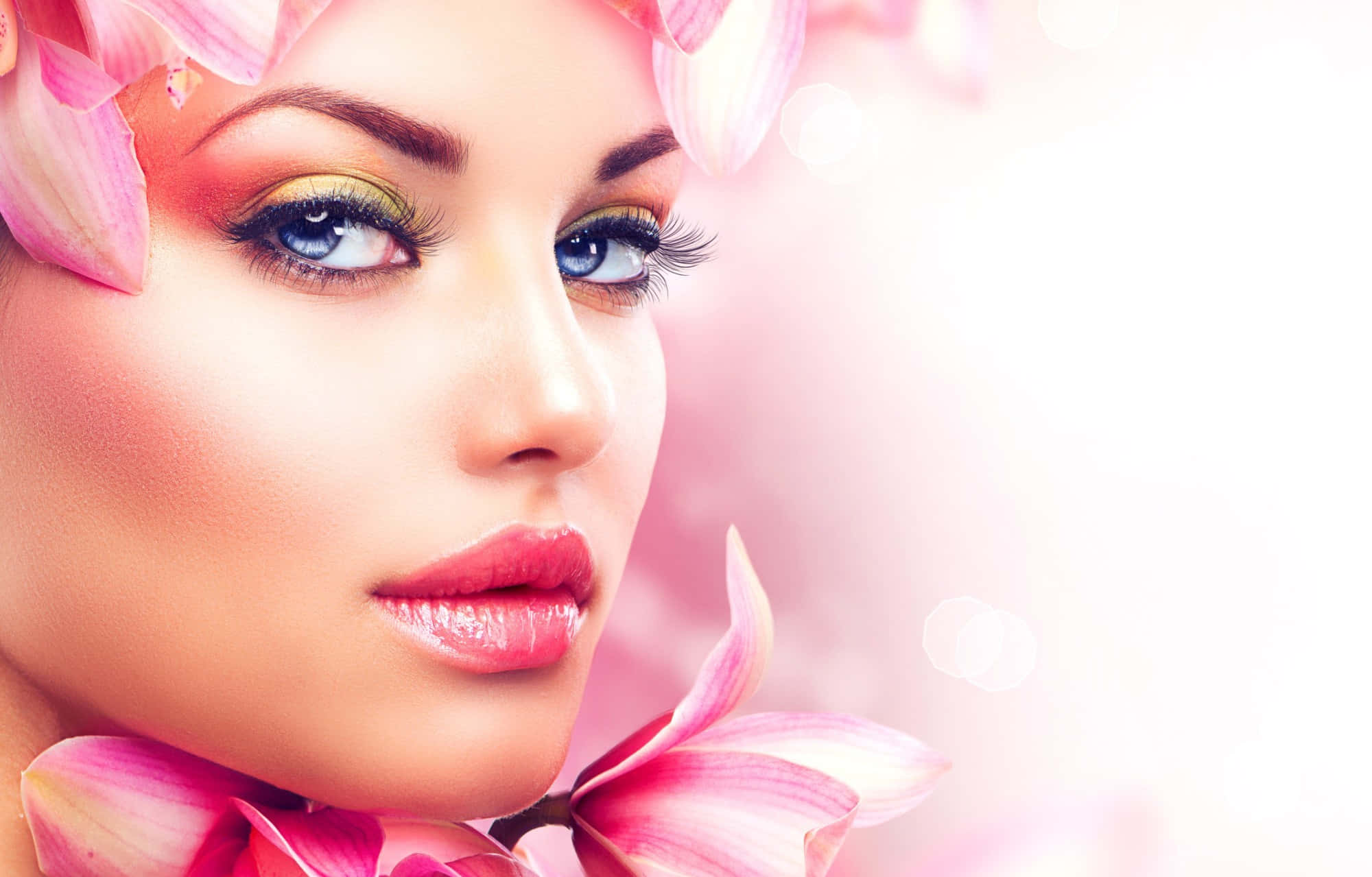 靚女gif 桌布 壁紙 — 一位擁有引人注目藍眼睛的女子的特寫肖像，頭部和肩膀周圍裝飾著粉紅色蘭花花瓣。