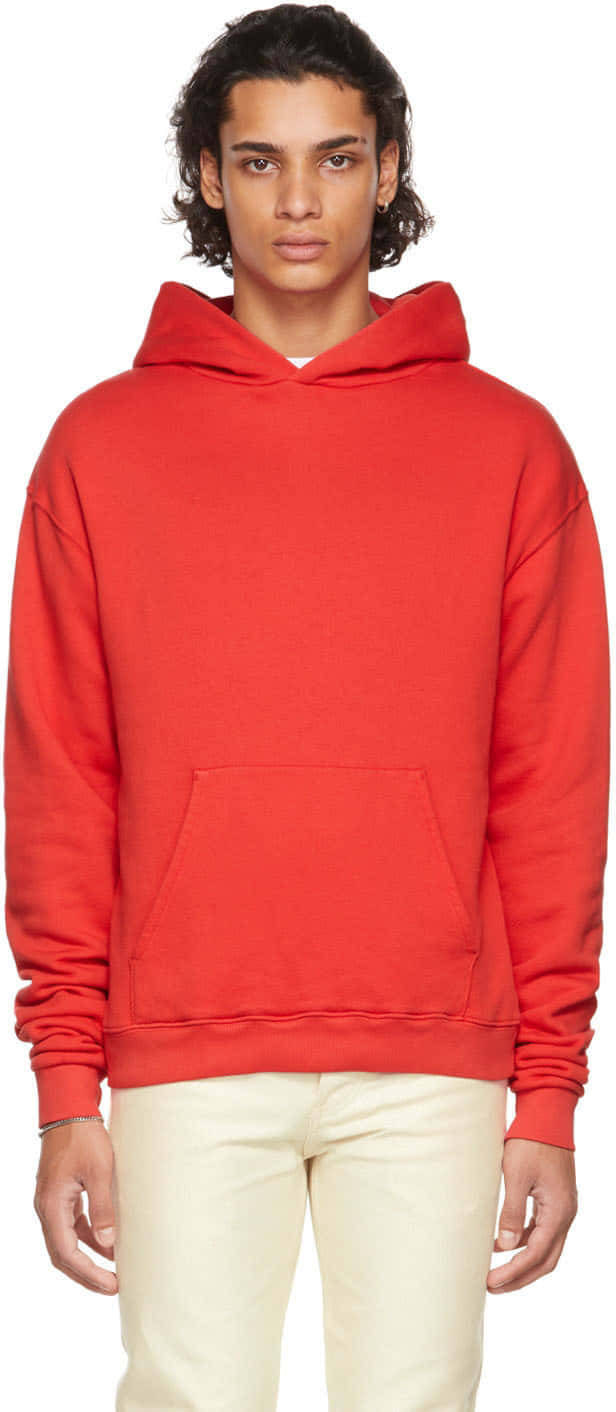 Red Hoodie 桌布 壁紙 — 一位擁有深色捲髮的年輕男士，穿著一件大膽的紅色連帽衫和米色褲子，背景是純白色。