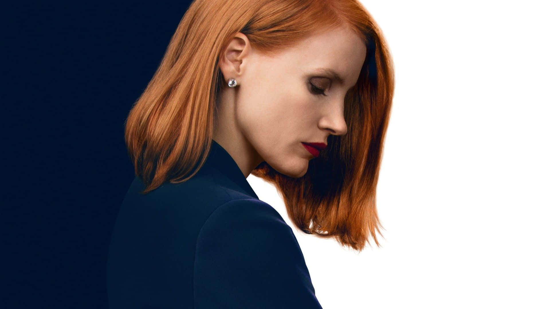 jessica chastain 桌布 壁紙 — 一位擁有火紅頭髮和大膽紅唇的女性，在鮮明的黑白背景下向下凝視。
