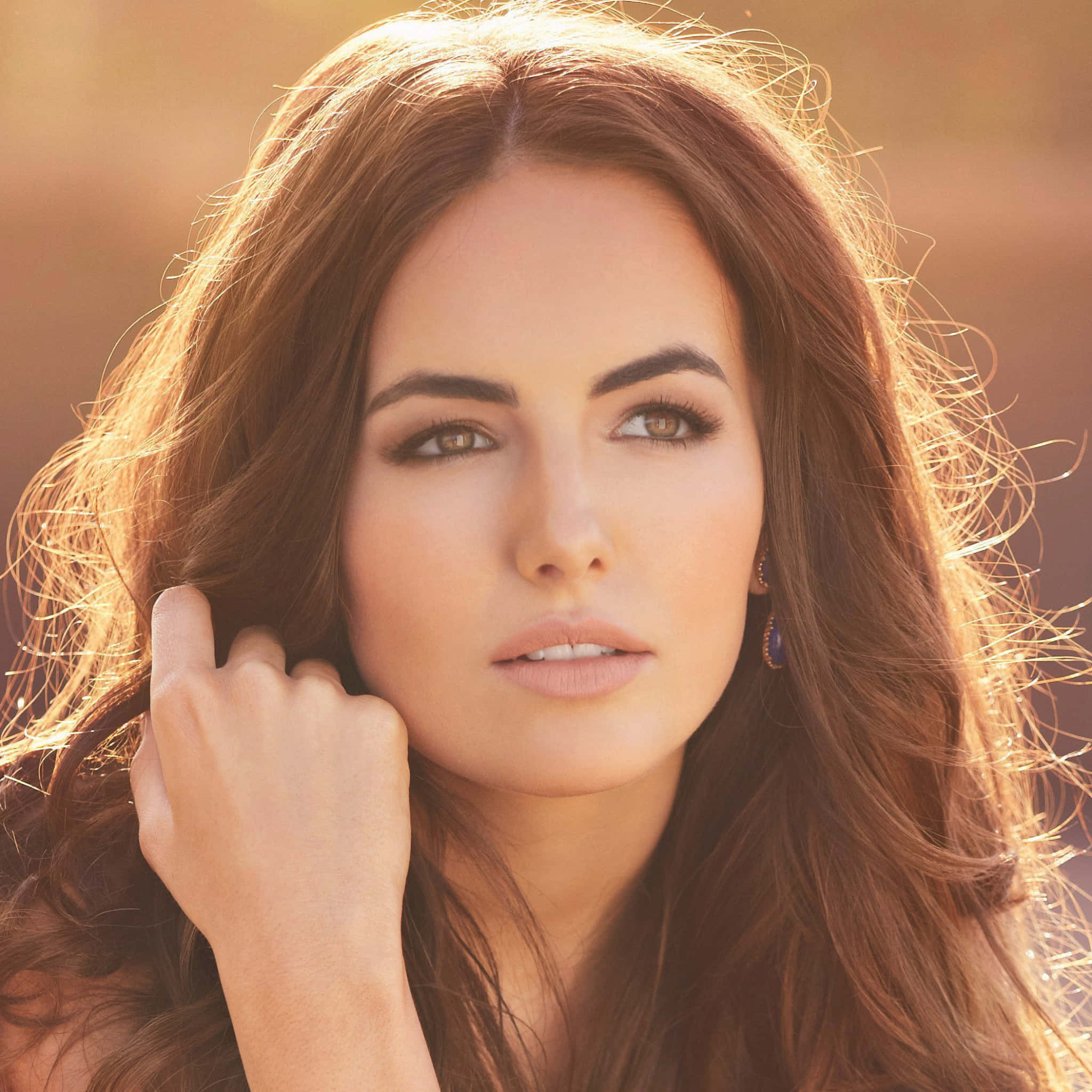Camilla Belle 桌布 壁紙 — 一位擁有長長棕色頭髮的女性，在金色陽光突出她的髮絲和臉龐時，若有所思地凝視著。