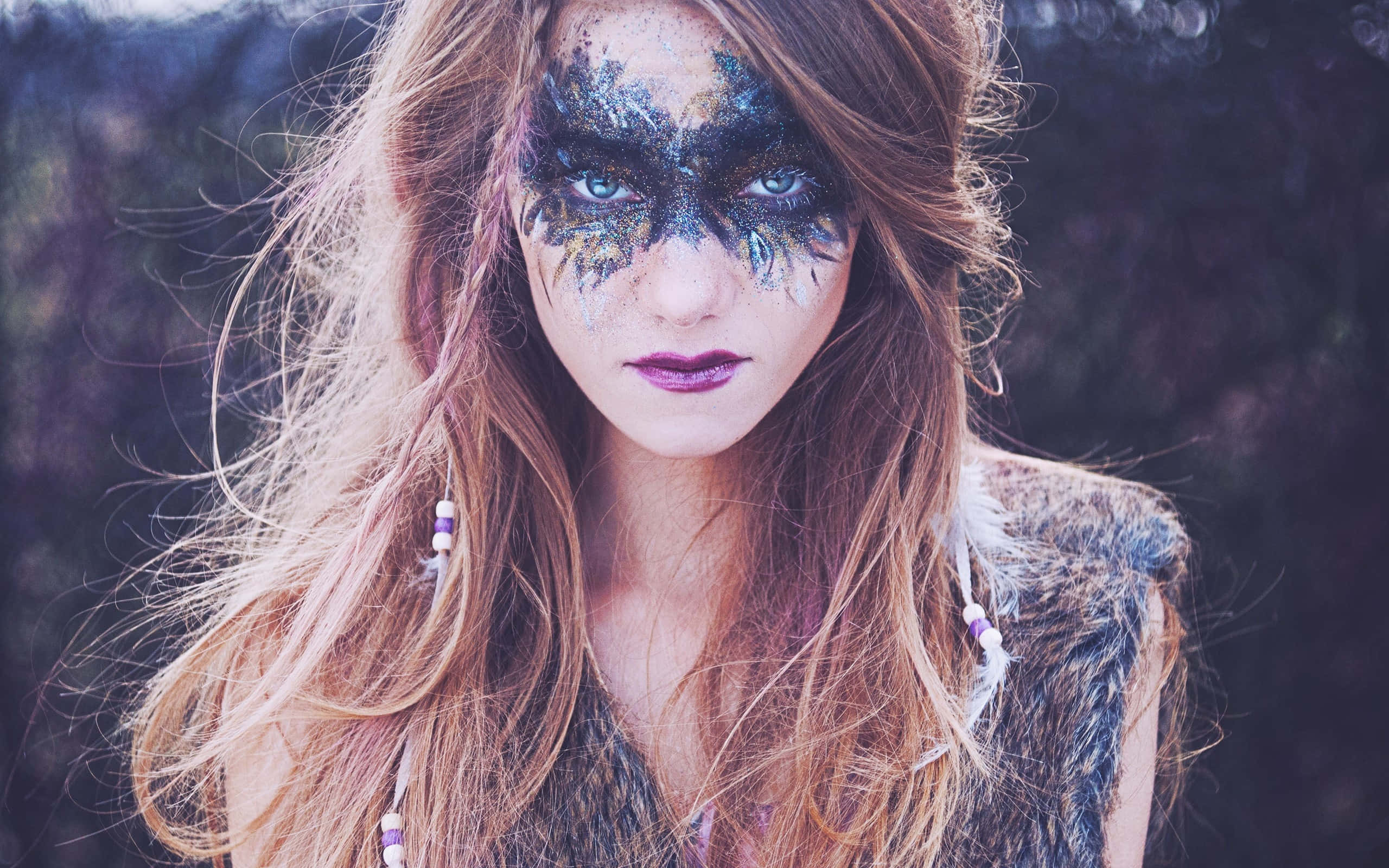 Halloween Makeup 桌布 壁紙 — 一位擁有長長飄逸秀髮和精緻藍黑葉紋臉部彩繪的女性直視鏡頭。