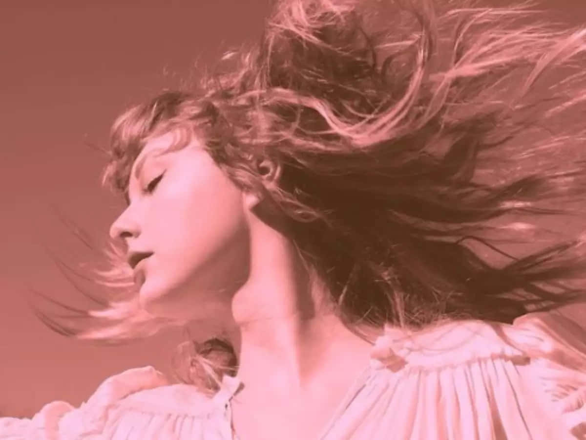 Taylor Swift 桌布 壁紙 — 一位擁有飄逸長髮的女性，在柔和的漸變背景前，以夢幻般的粉紅色單色肖像捕捉。