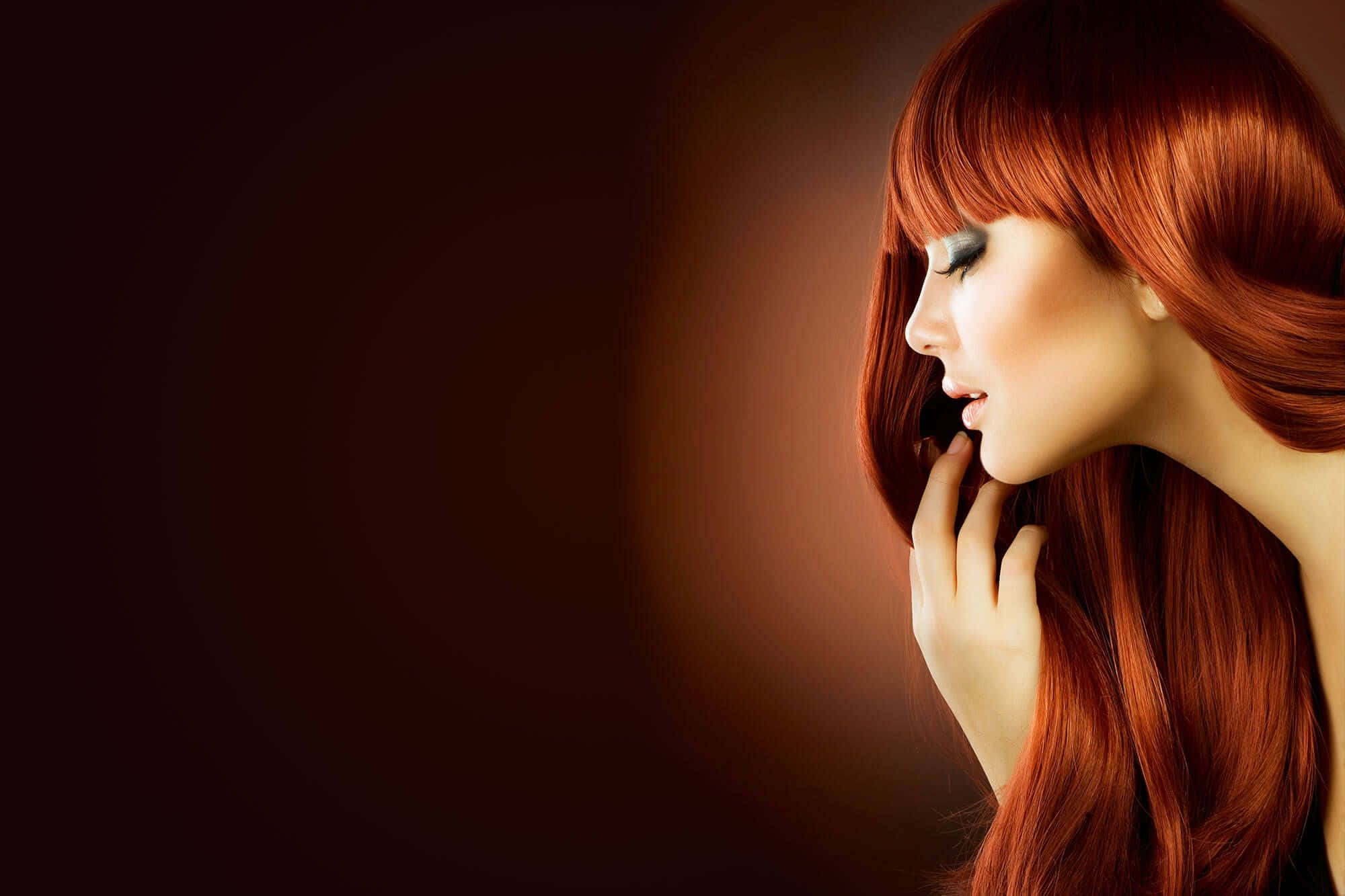 Beauty Salon 桌布 壁紙 — 一位擁有鮮豔紅髮且閉著眼睛的女性，輕輕地將臉頰貼在深色溫暖的漸變背景上。