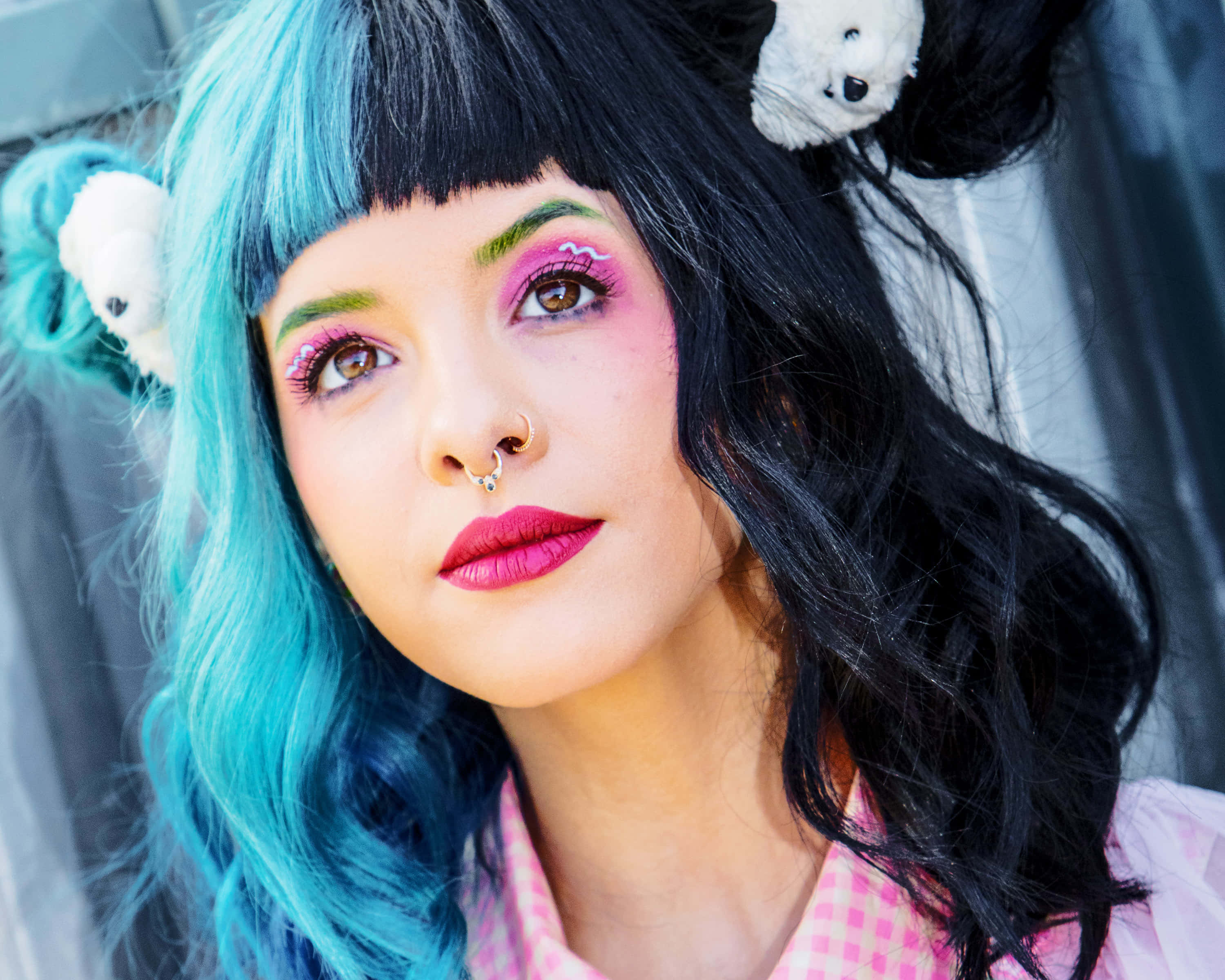 Melanie Martinez 桌布 壁紙 — 一位擁有鮮豔藍色頭髮和粉紅色化妝的年輕女性，戴著白色泰迪熊髮夾，直視鏡頭。