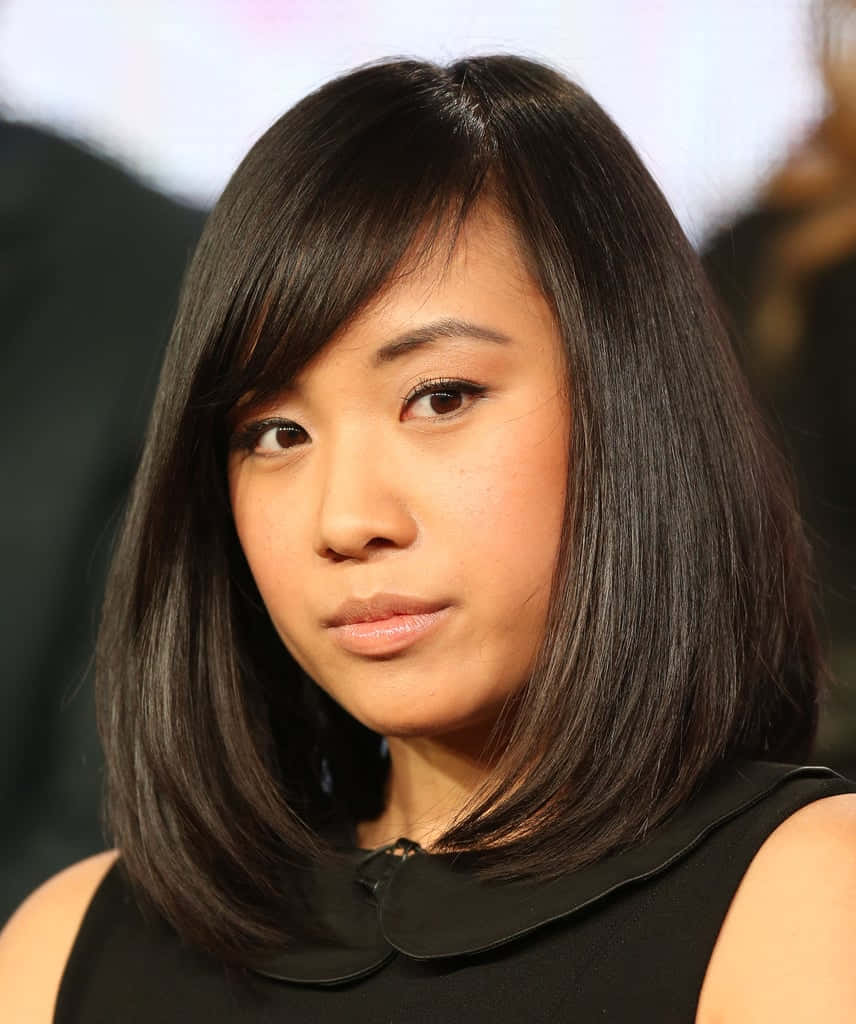 Ellen Wong 桌布 壁紙 — 一位擁有黑色直髮、身穿黑色無袖上衣的女性特寫肖像，背景模糊。