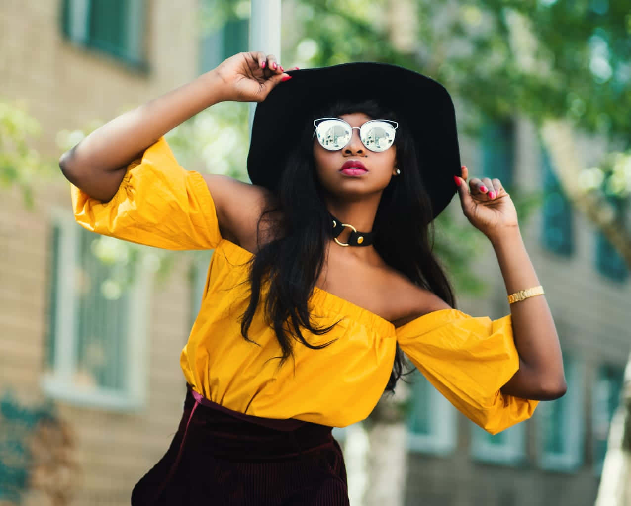 Yellow Fashion 桌布 壁紙 — 一位時尚女性身穿黃色上衣和黑色帽子，戴著反光太陽眼鏡，自信地在戶外擺姿勢。