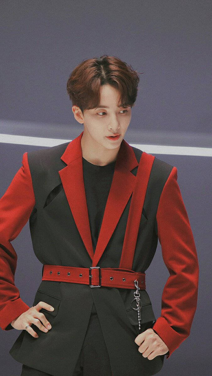Yoon Jeonghan 24H 壁紙 — 一位時尚的年輕男士穿著大膽的紅黑西裝，在簡約的灰色背景前自信地擺姿勢。