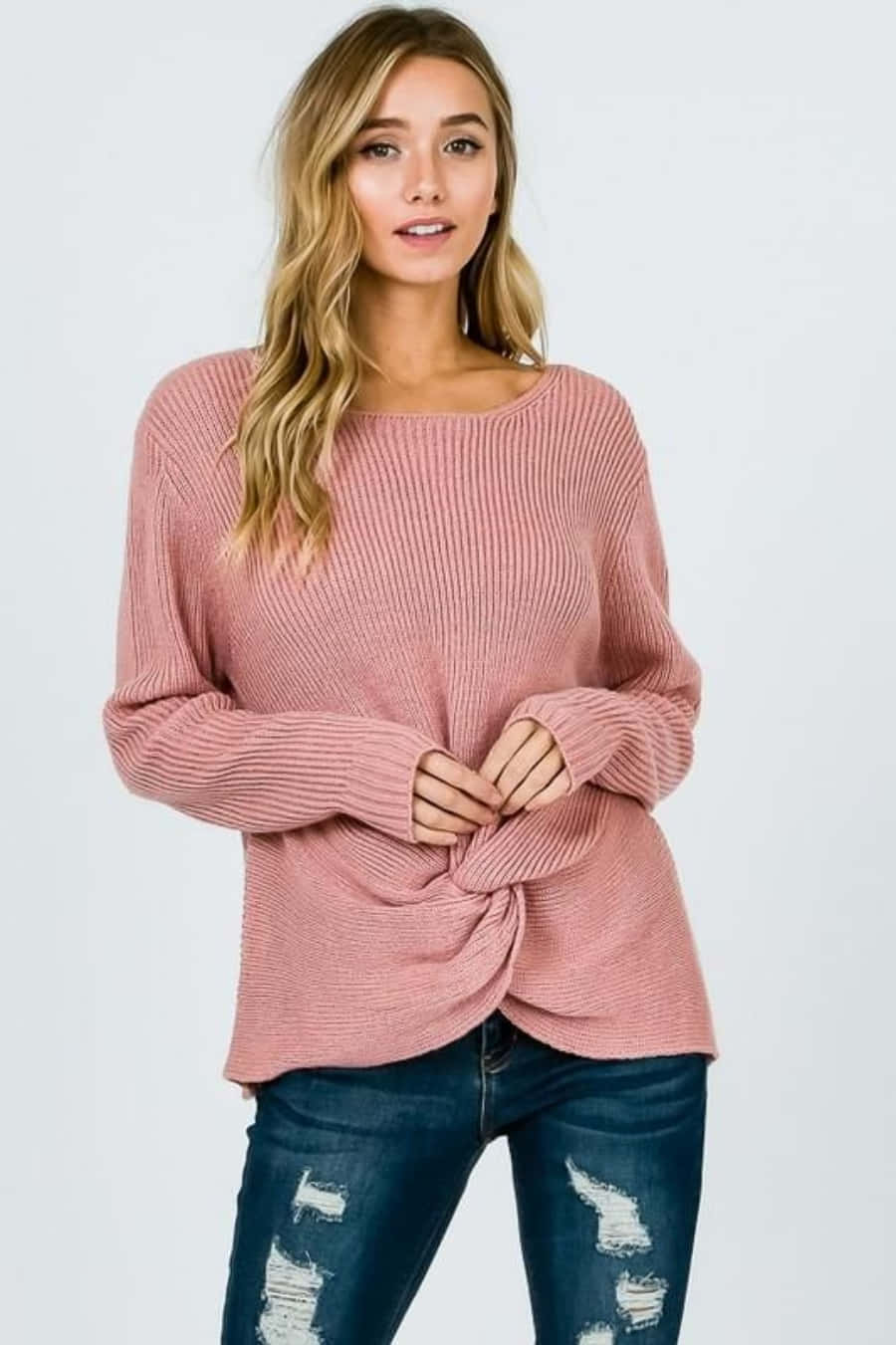 Pink Sweater 桌布 壁紙 — 一位波浪金髮女性穿著粉紅色羅紋毛衣，前面打結，搭配破洞藍色牛仔褲，背景為純白色。