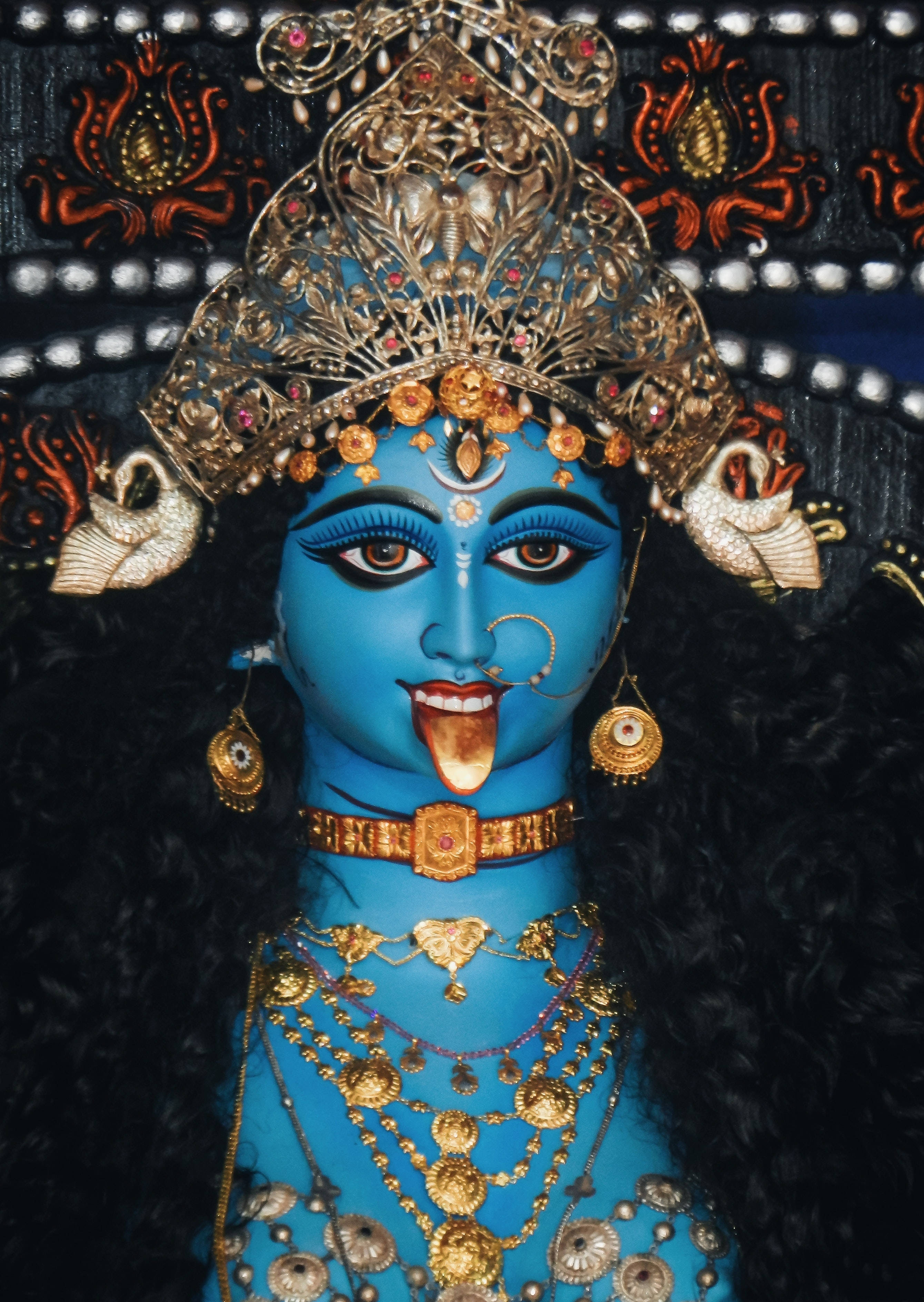 Goddess 桌布 壁紙 — 一位生動的藍皮膚女神，飾以精緻的金飾和鑲有寶石的皇冠，舌頭伸出，呈現神聖姿態。