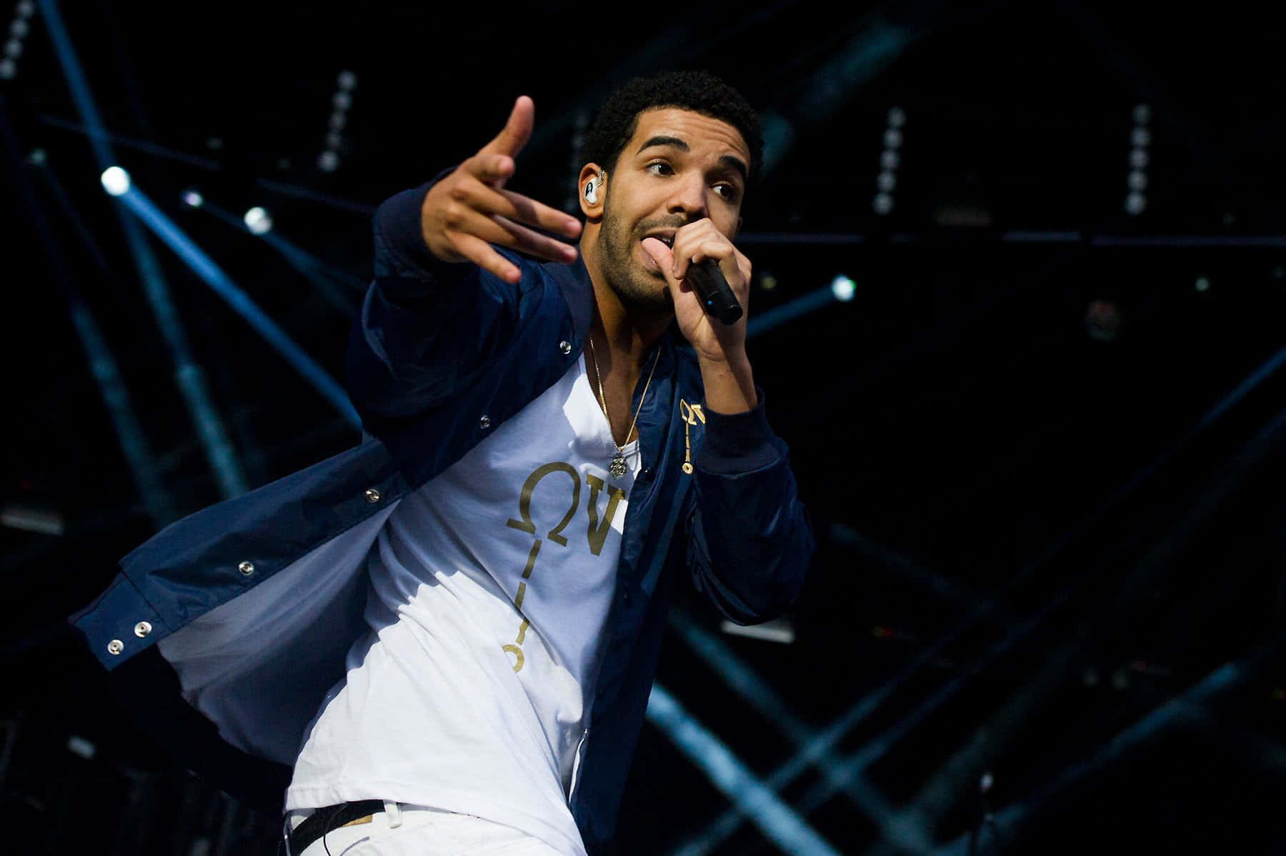 Drake 桌布 壁紙 — 一位男歌手在明亮的藍色聚光燈下，以動態的手勢在舞台上充滿激情地表演。