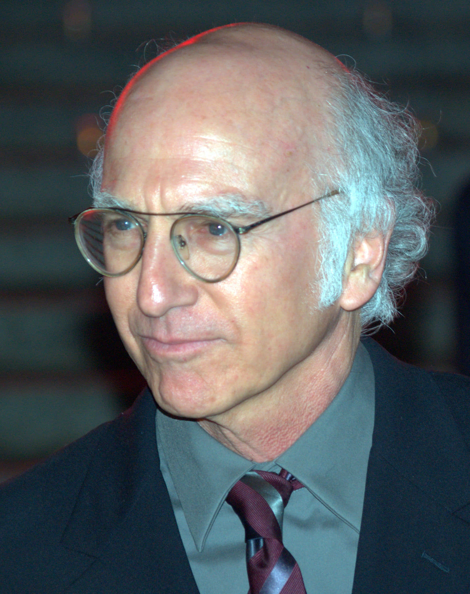 larry david 桌布 壁紙 — 一位白髮、戴圓框眼鏡、穿著西裝打領帶的禿頭男士的特寫肖像。