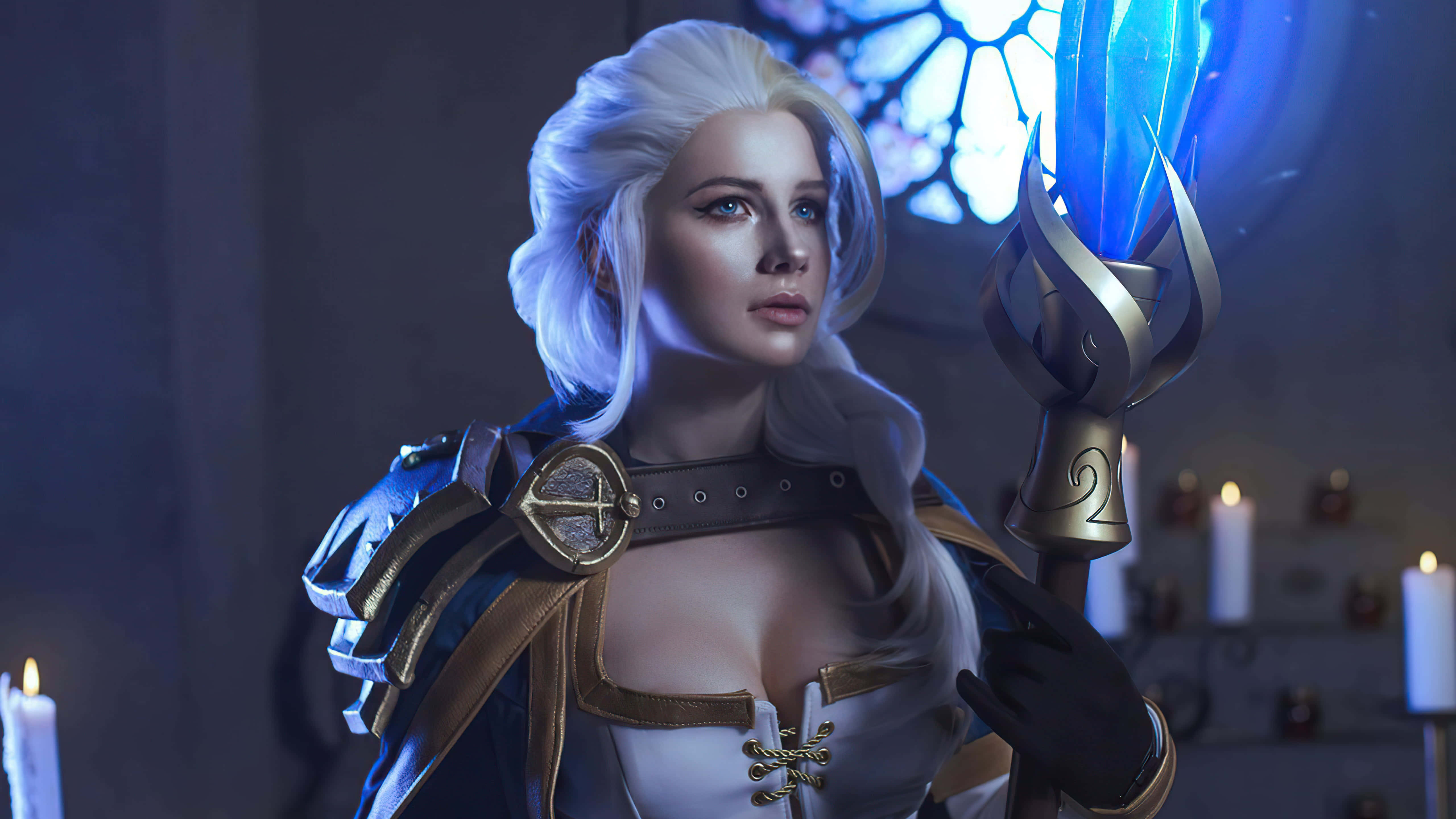 Gaming Cosplay 桌布 壁紙 — 一位白髮奇幻女戰士在燭光閃爍的彩繪玻璃大教堂中手持發光藍色法杖。