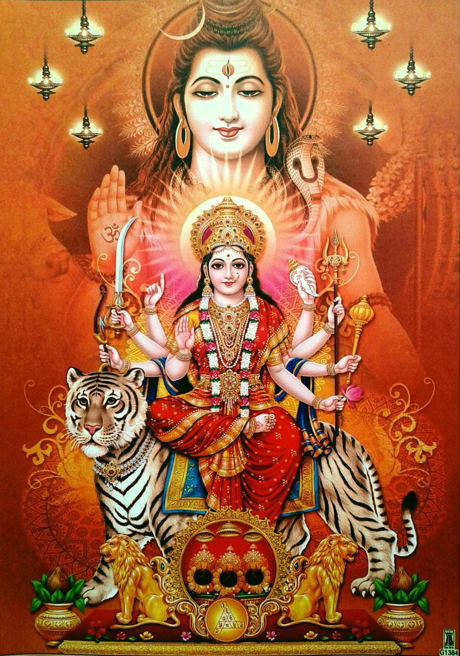 Vaishno Devi 桌布 壁紙 — 一位神聖的印度教女神，多臂，威嚴地坐在飾有金獅和華麗燈飾的老虎寶座上，背景是燦爛的橙色。