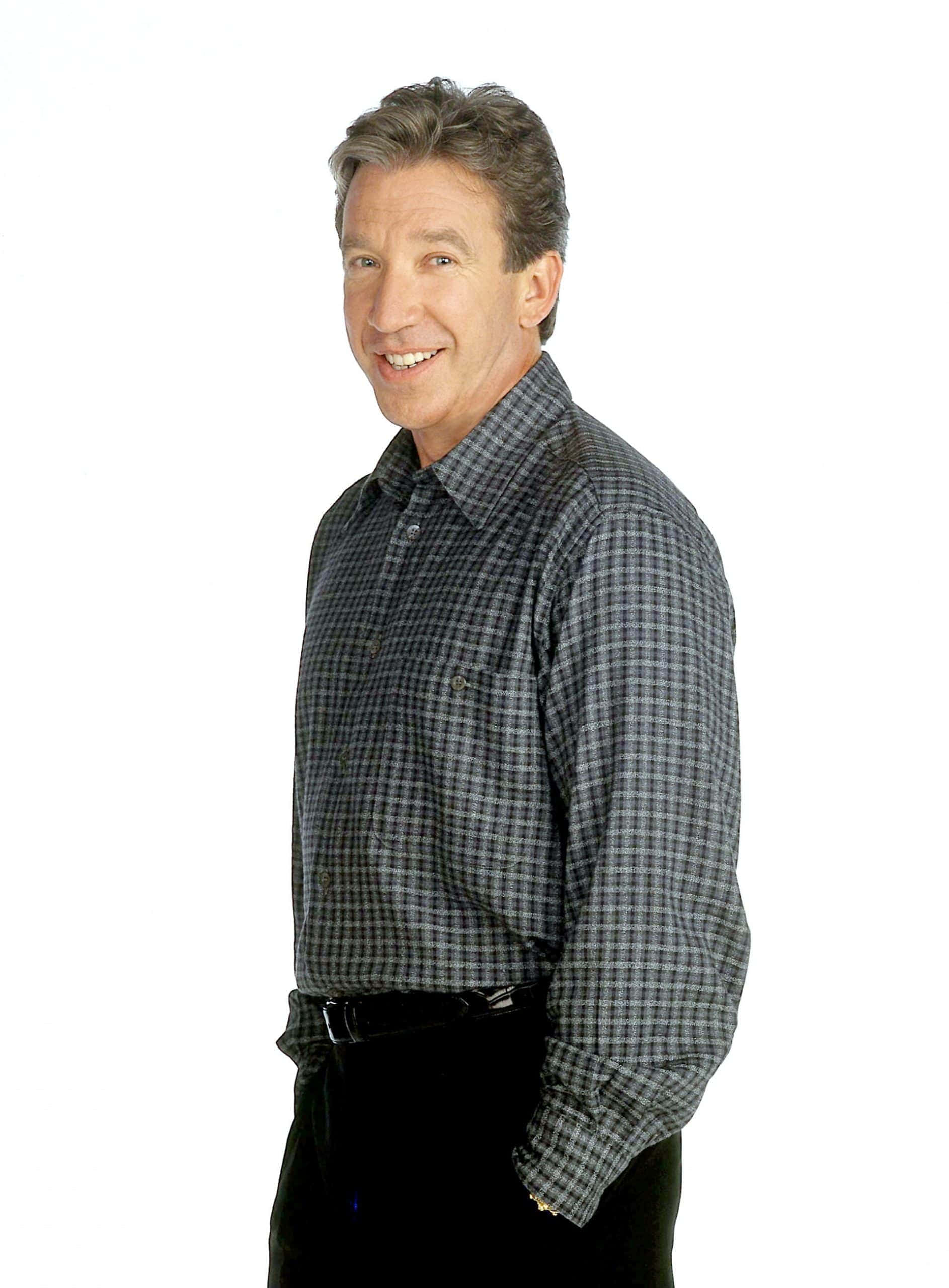 Tim Allen 桌布 壁紙 — 一位穿著格仔恤衫嘅開心中年男人喺純白色背景前溫暖咁微笑。