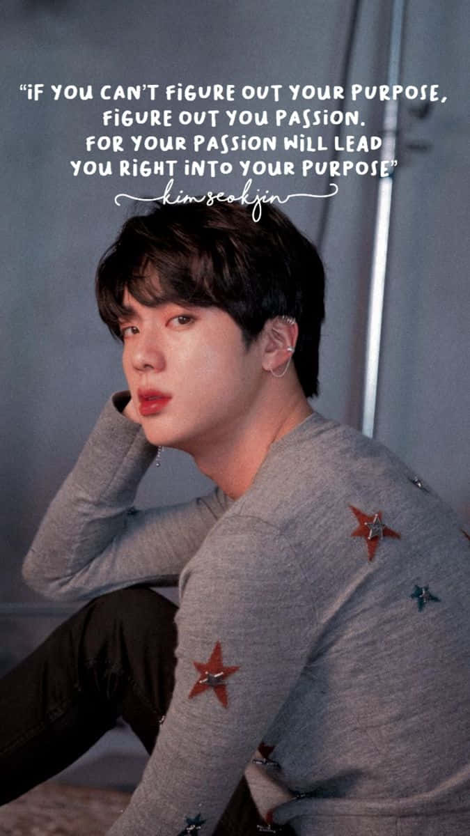 Bts Inspirational 桌布 壁紙 — 一位穿著灰色星星圖案毛衣的年輕男子，在柔和的背景上沉思地坐著，並帶有引文疊加。