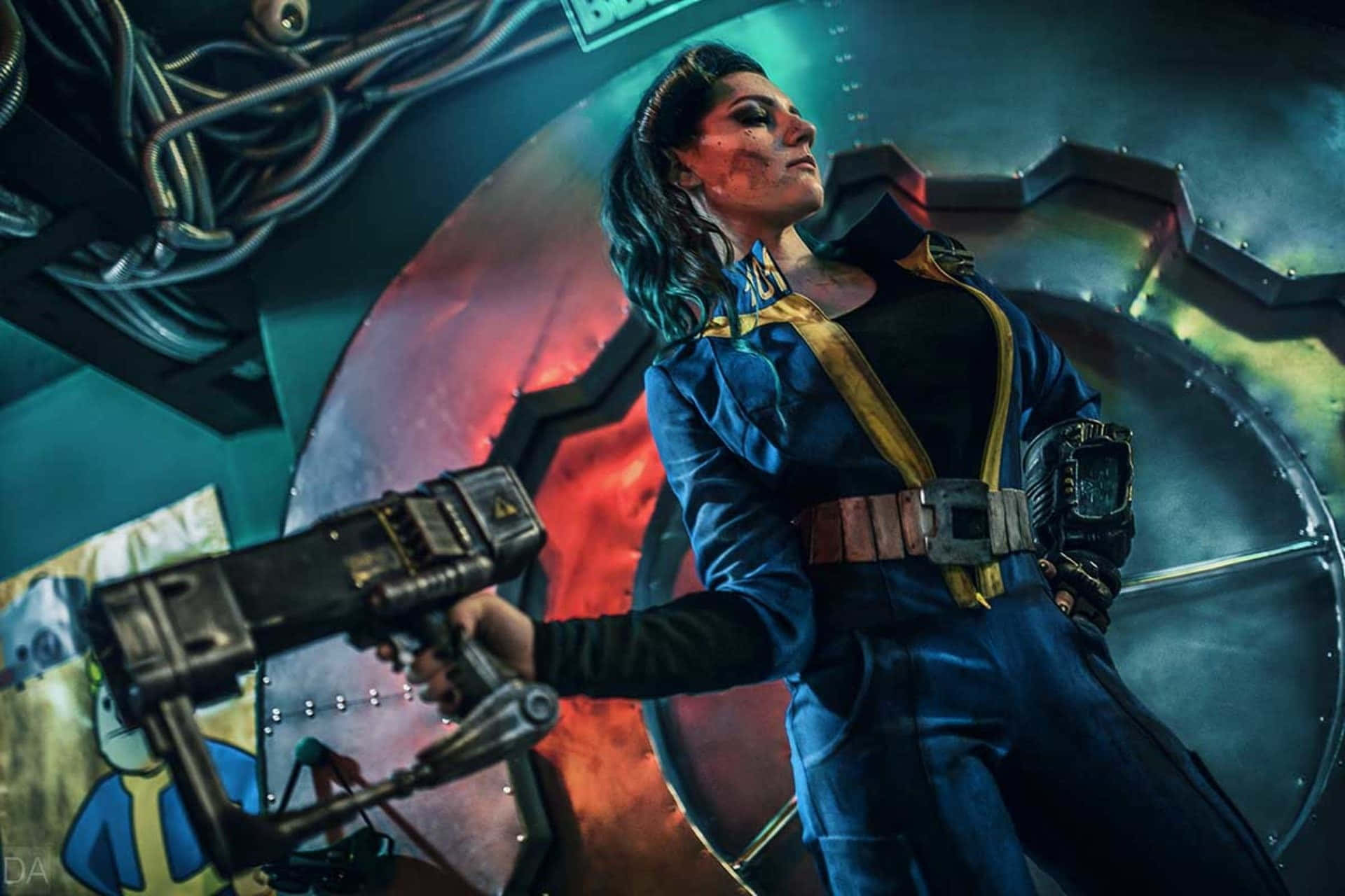Fallout 4 Vault 桌布 壁紙 — 一位穿著藍色Vault Dweller服裝的角色扮演者在發光的金屬拱頂室內手持未來武器。