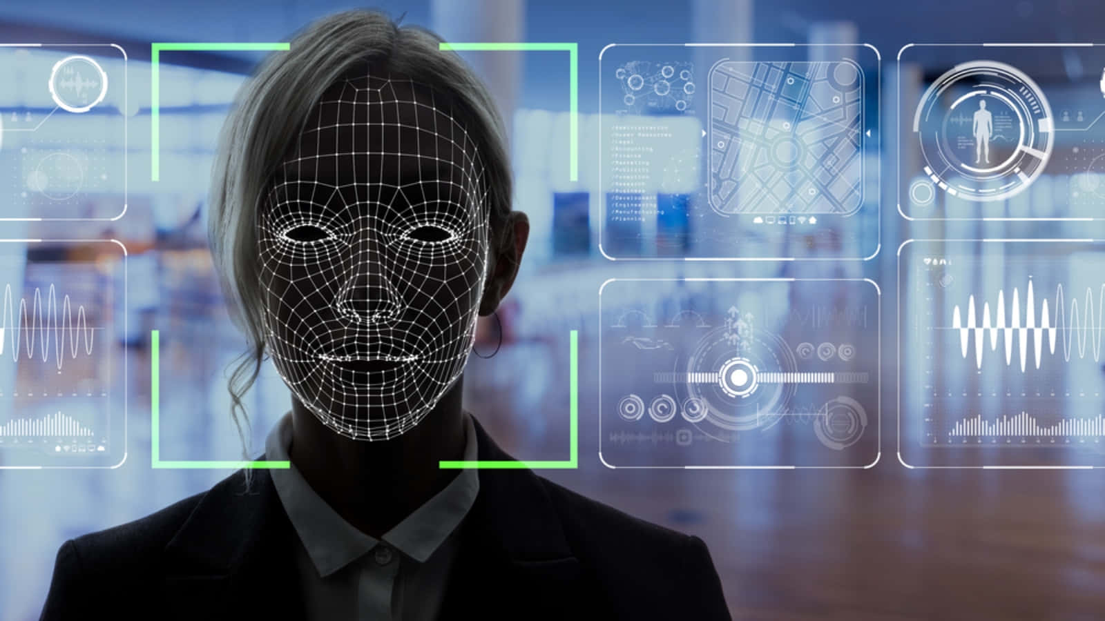 Face Recognition 桌布 壁紙 — 一位穿著西裝的女性，在未來風格的辦公室中，帶有數位線框臉部疊加，配有發光的綠色掃描框和浮動數據面板。