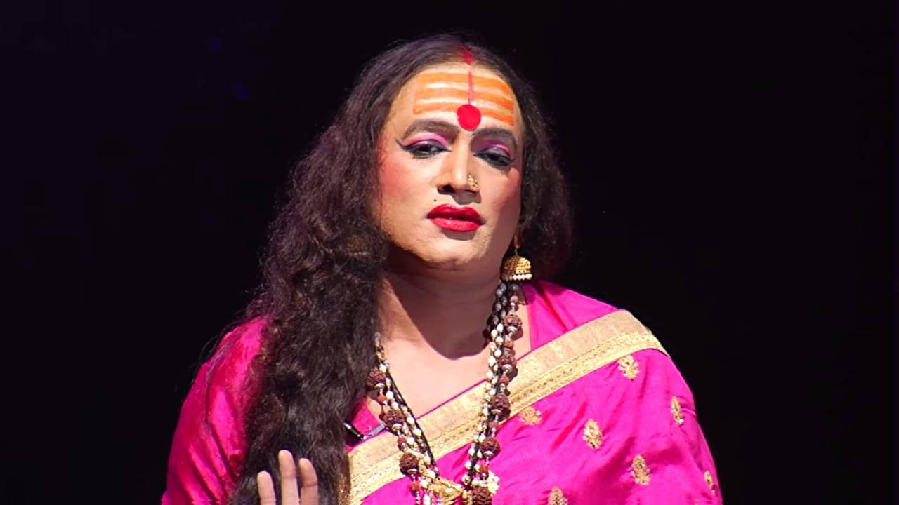 Indian 桌布 壁紙 — 一位穿著鮮豔粉紅色傳統服飾、額頭有橙色標記的人在黑暗的舞台上表演。