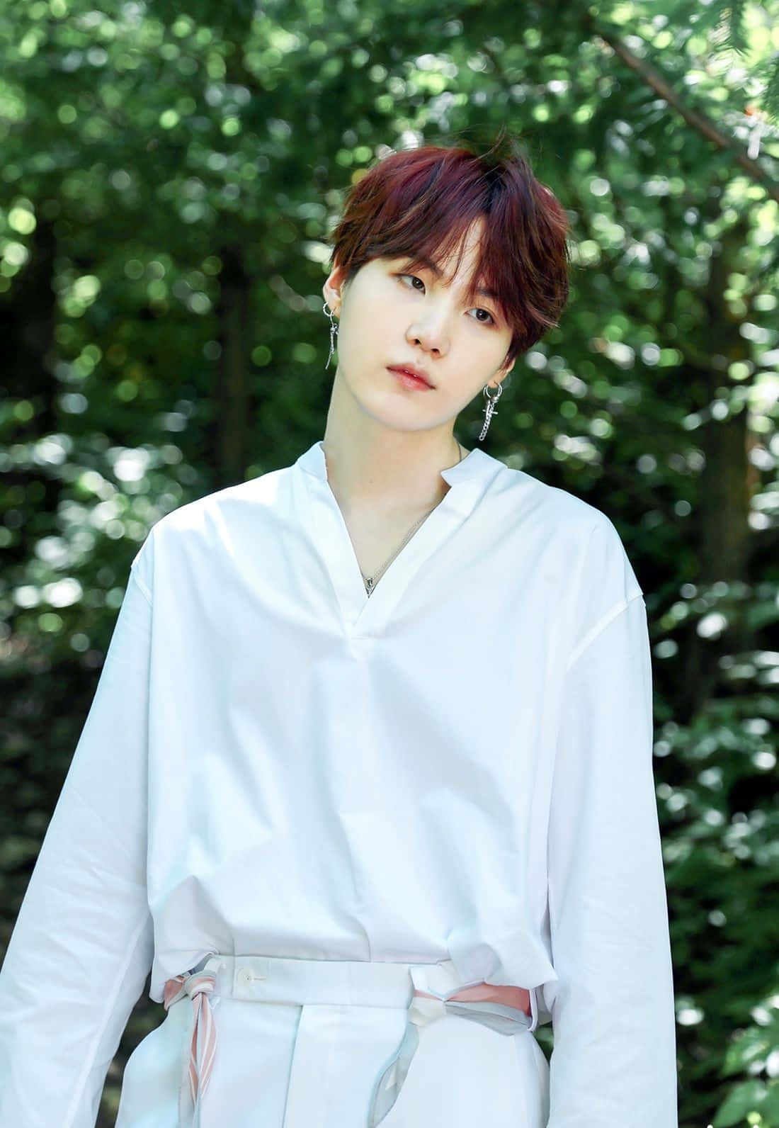 Suga 桌布 壁紙 — 一位紅髮戴銀耳環的年輕男子，身穿白色服裝，背景是鬱鬱蔥蔥的綠色森林。