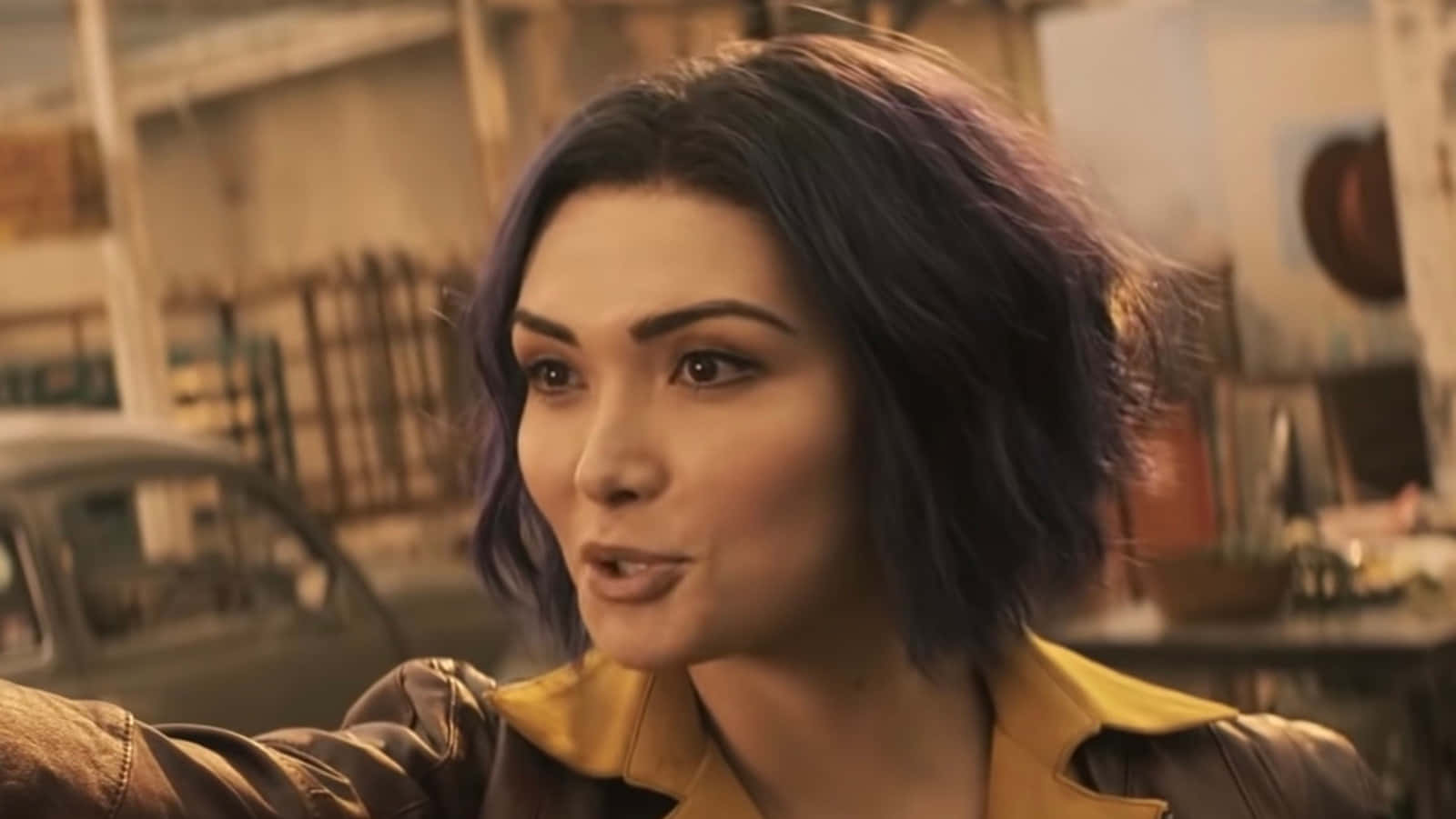 Faye Valentine 桌布 壁紙 — 一位紫髮女子身穿皮褸，在粗獷的城市環境中專注地向前凝視。