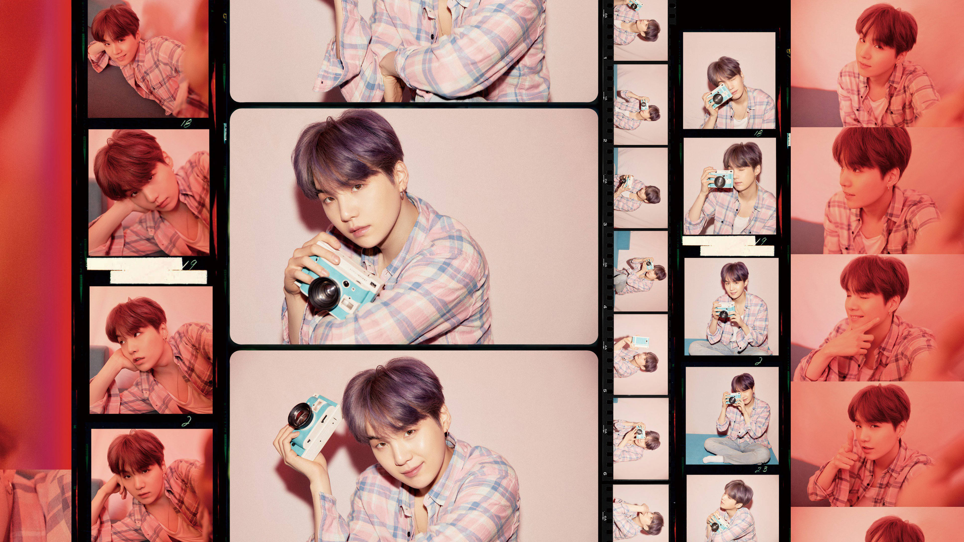 SUGA Film Strip 壁紙 — 一位紫髮年輕男子穿著格仔襯衫，在多個菲林條風格的框架中拿著相機擺姿勢，沐浴在溫暖的粉紅光中。