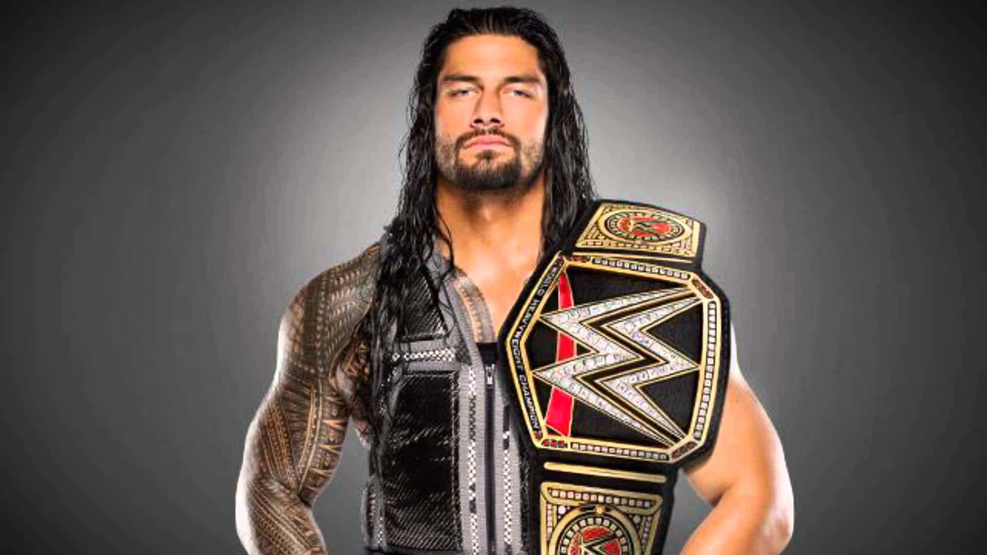 WWE Logo 桌布 壁紙 — 一位肌肉發達的摔角手，留著深色長髮和紋身，在深色漸變背景上佩戴閃亮的冠軍腰帶。