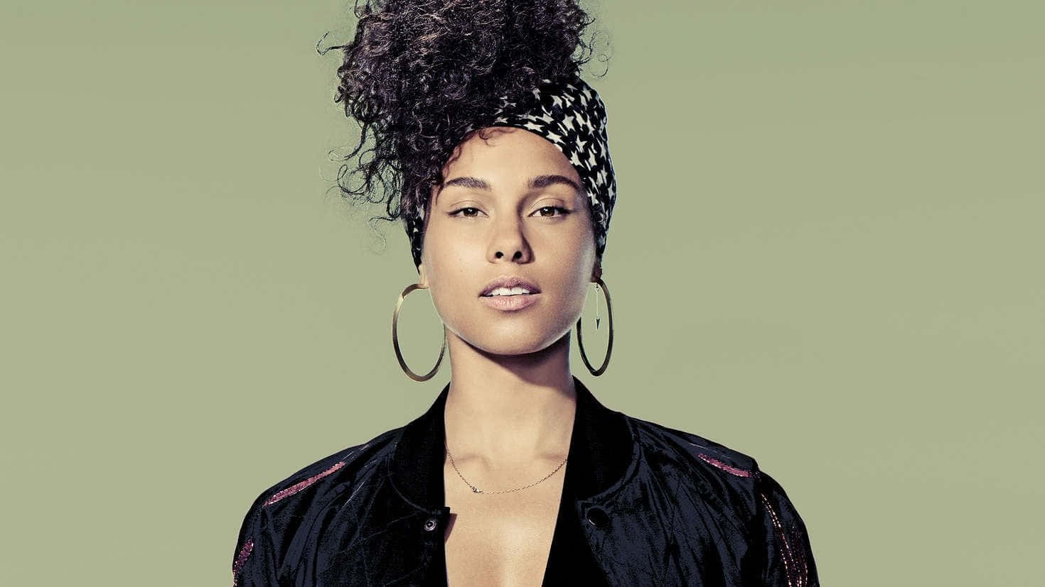 Alicia Keys 桌布 壁紙 — 一位自信嘅女人，曲髮，戴住星星圖案頭巾同大圈耳環，喺柔和綠色背景前擺甫士。