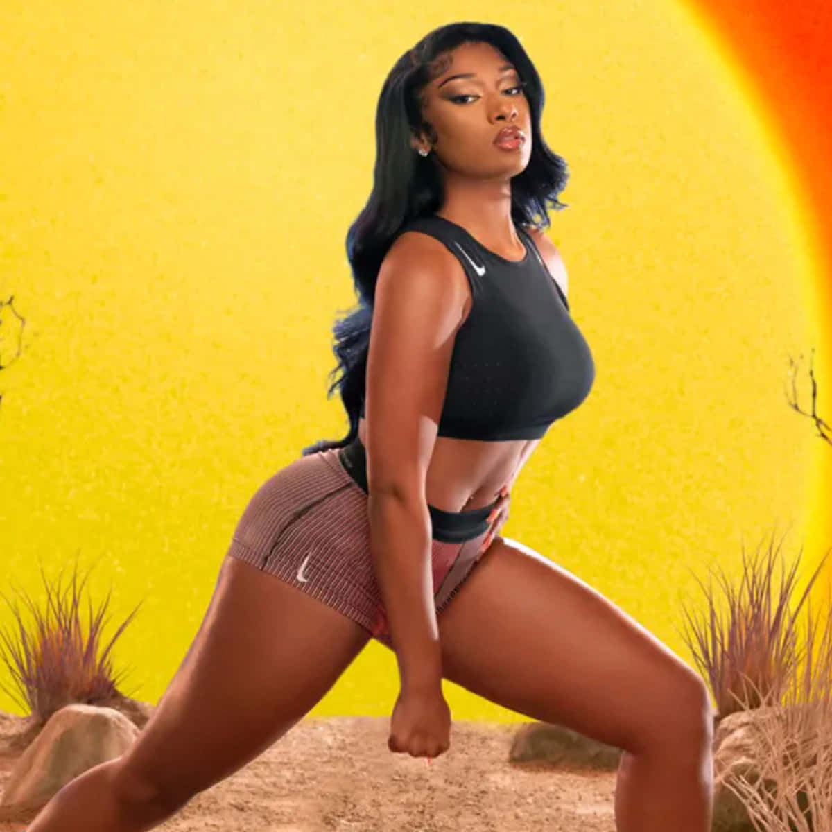 Megan Thee Stallion 桌布 壁紙 — 一位自信的女性穿著運動服，在充滿活力的黃色和橙色沙漠背景下，以風格化的太陽為襯托，擺出強而有力的姿勢。