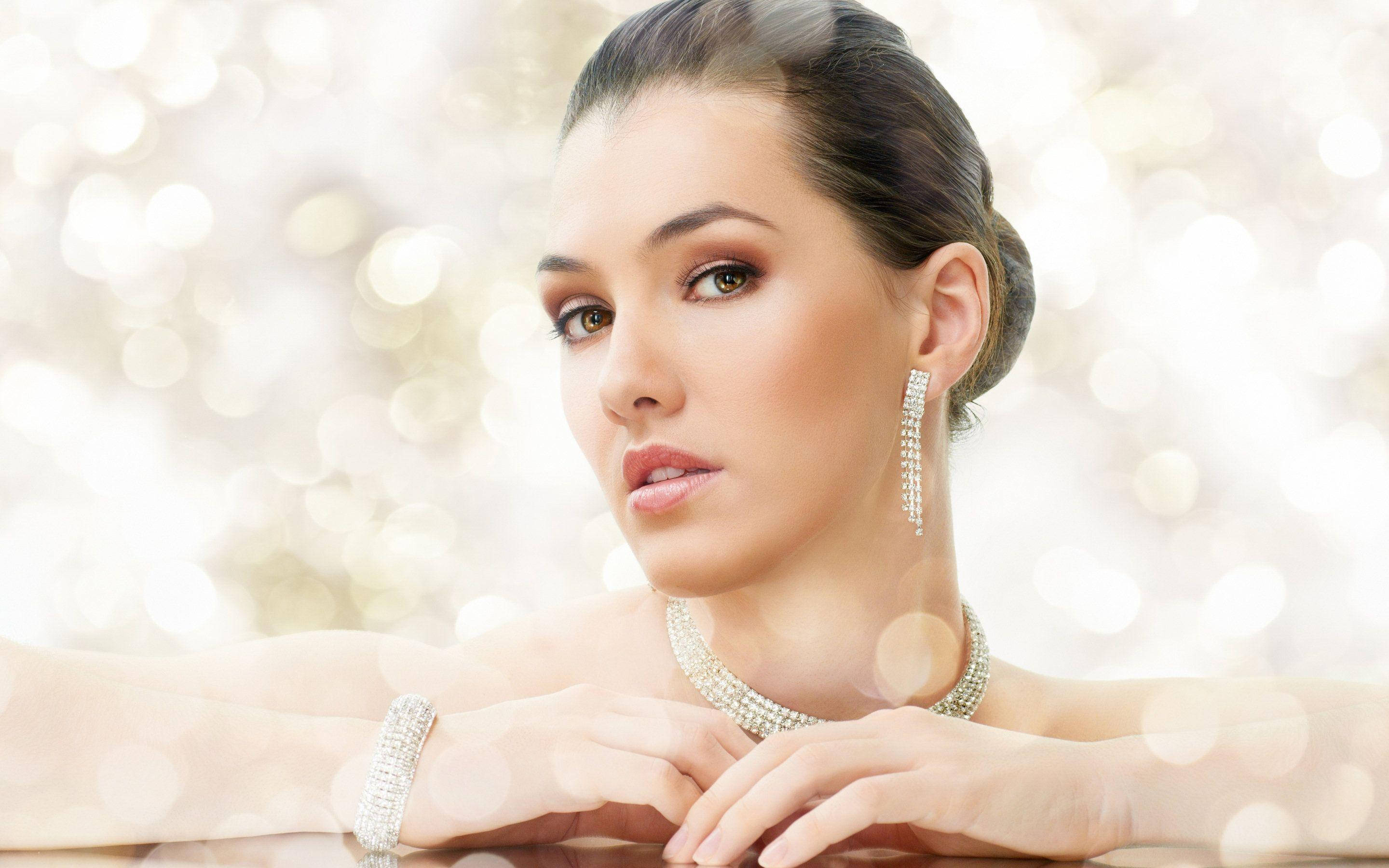Beautiful Woman 桌布 壁紙 — 一位華麗的女性佩戴著閃閃發光的鑽石首飾，在璀璨的散景背景下溫柔地凝視。