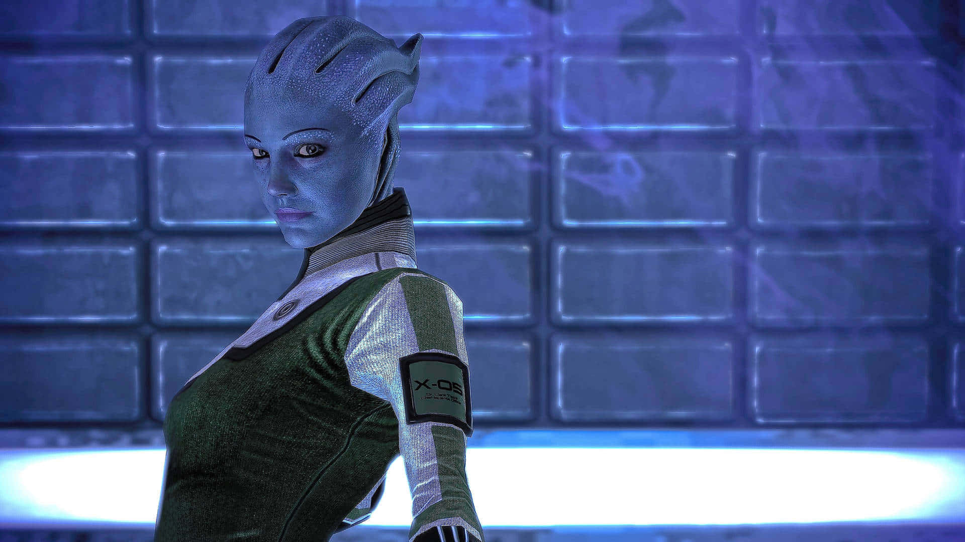 Liara T'soni 桌布 壁紙 — 一位藍皮膚的外星女性穿著綠色和白色的制服，站在一個未來主義的藍色照明房間裡，牆壁鋪滿瓷磚。