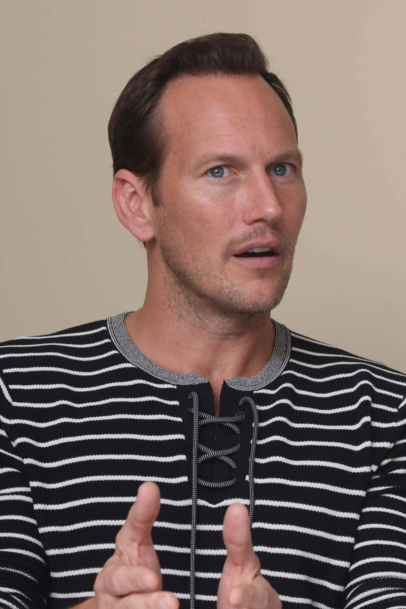Patrick Wilson 桌布 壁紙 — 一位藍眼睛、深色頭髮的男子穿著黑白條紋襯衫，雙手比劃著手勢。
