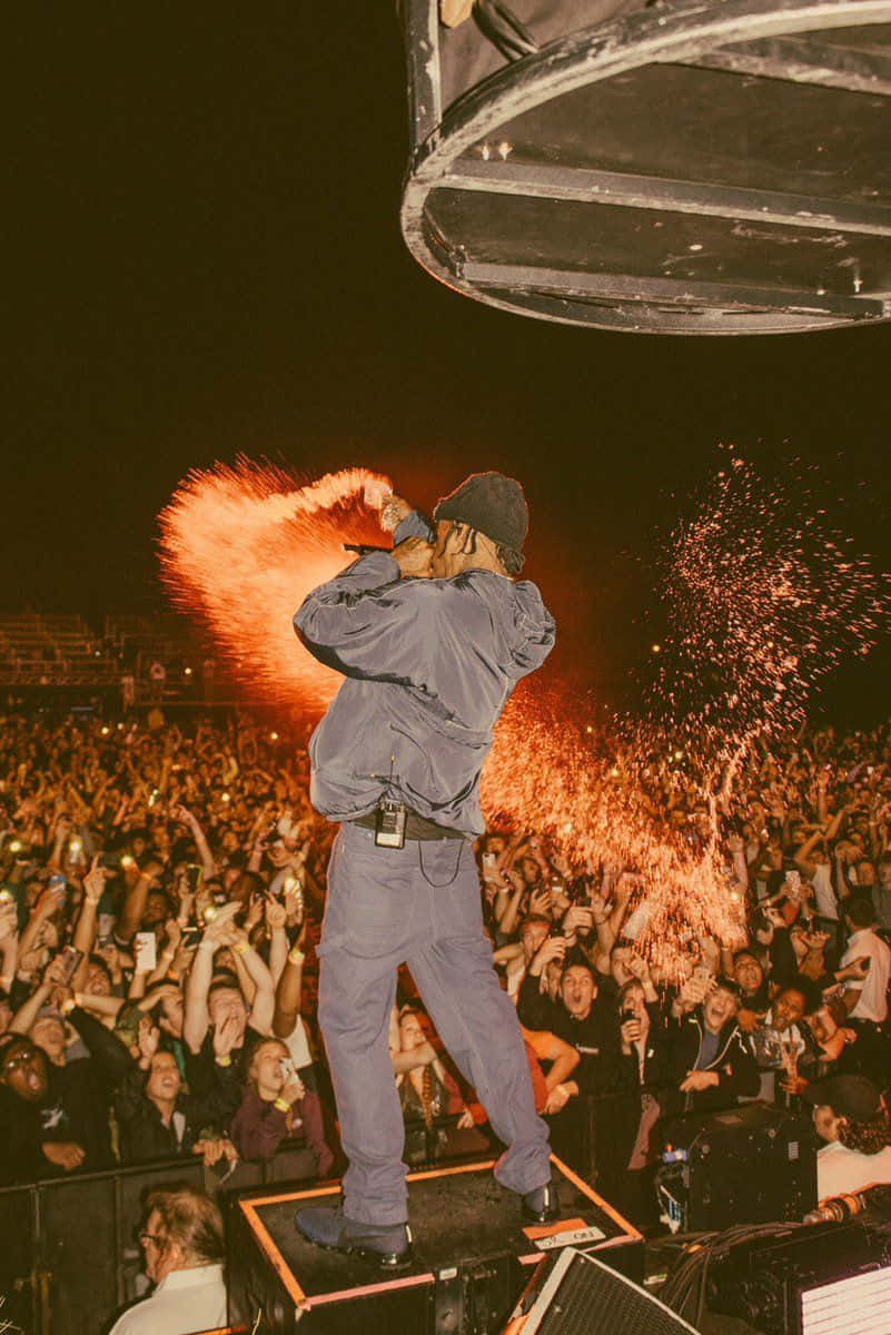 Drake 桌布 壁紙 — 一位表演者在夜間舞台上釋放出熾熱的火花，一群粉絲在黑暗的天空下舉起手機歡呼。