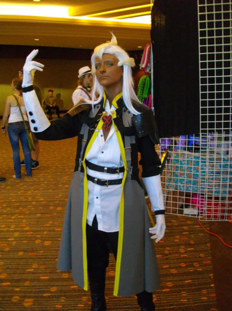 Ansem Seeker Of Darkness 桌布 壁紙 — 一位角色扮演者穿著細節豐富的白色和黑色服裝，帶有黃色點綴，在會議廳中擺姿勢。