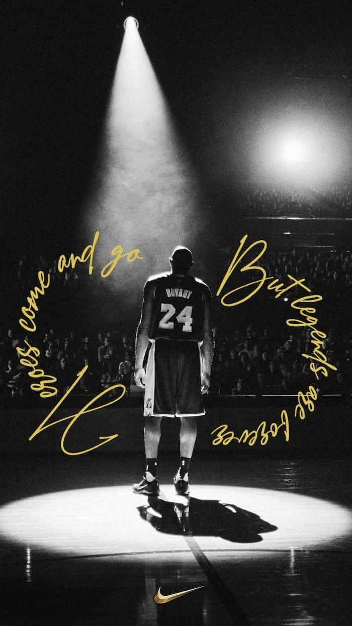 Kobe 桌布 壁紙 — 一位身穿24號球衣的籃球運動員獨自站在球場的聚光燈下，周圍有觀眾和金色字體的勵志語錄。