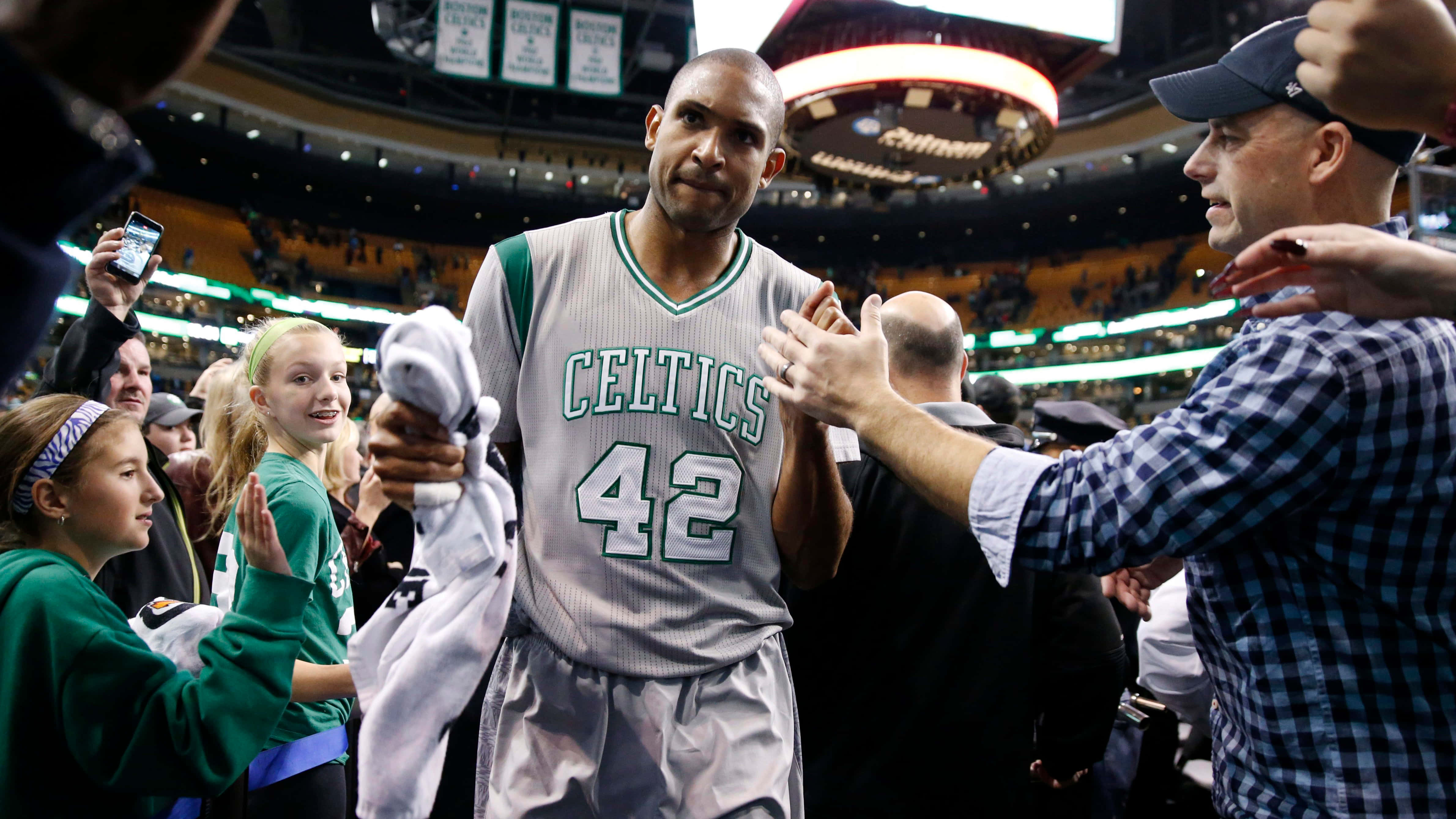 Al Horford 桌布 壁紙 — 一位身穿42號球衣的波士頓塞爾特人籃球運動員在擠滿觀眾的場館中與球迷擊掌和微笑打招呼。