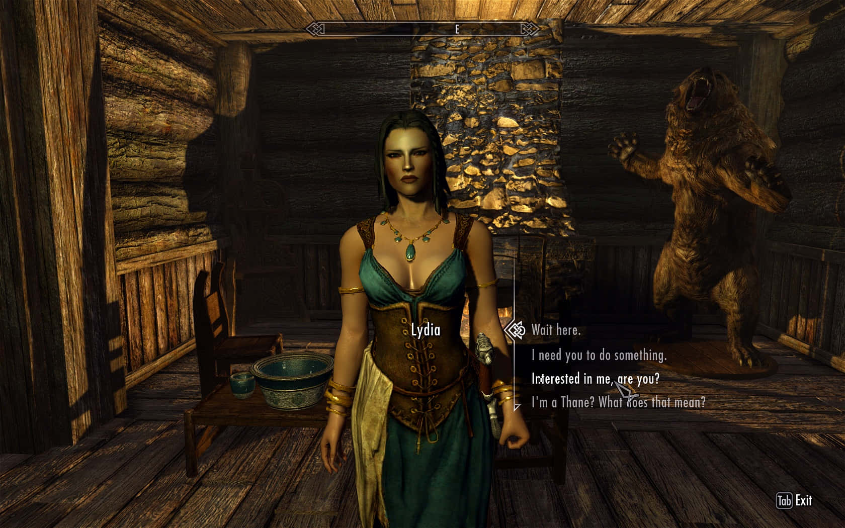 Skyrim Lydia 桌布 壁紙 — 一位身穿中世紀風格盔甲的女性站在質樸的木屋中，身後有一尊熊雕像。