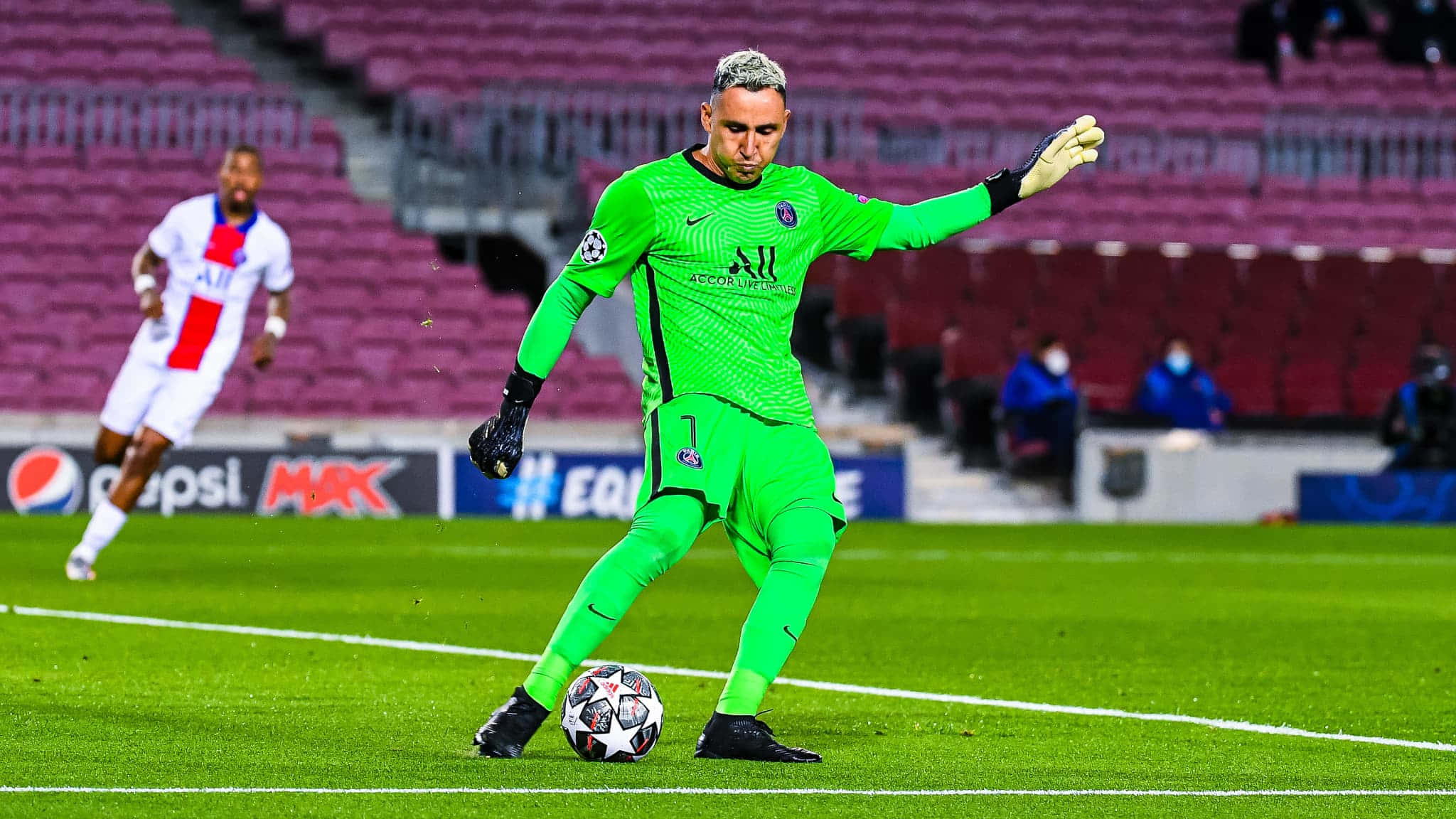Keylor Navas 桌布 壁紙 — 一位身穿亮綠色球衣的足球守門員在體育場燈光下，於充滿活力的綠色球場上準備踢出比賽用球。