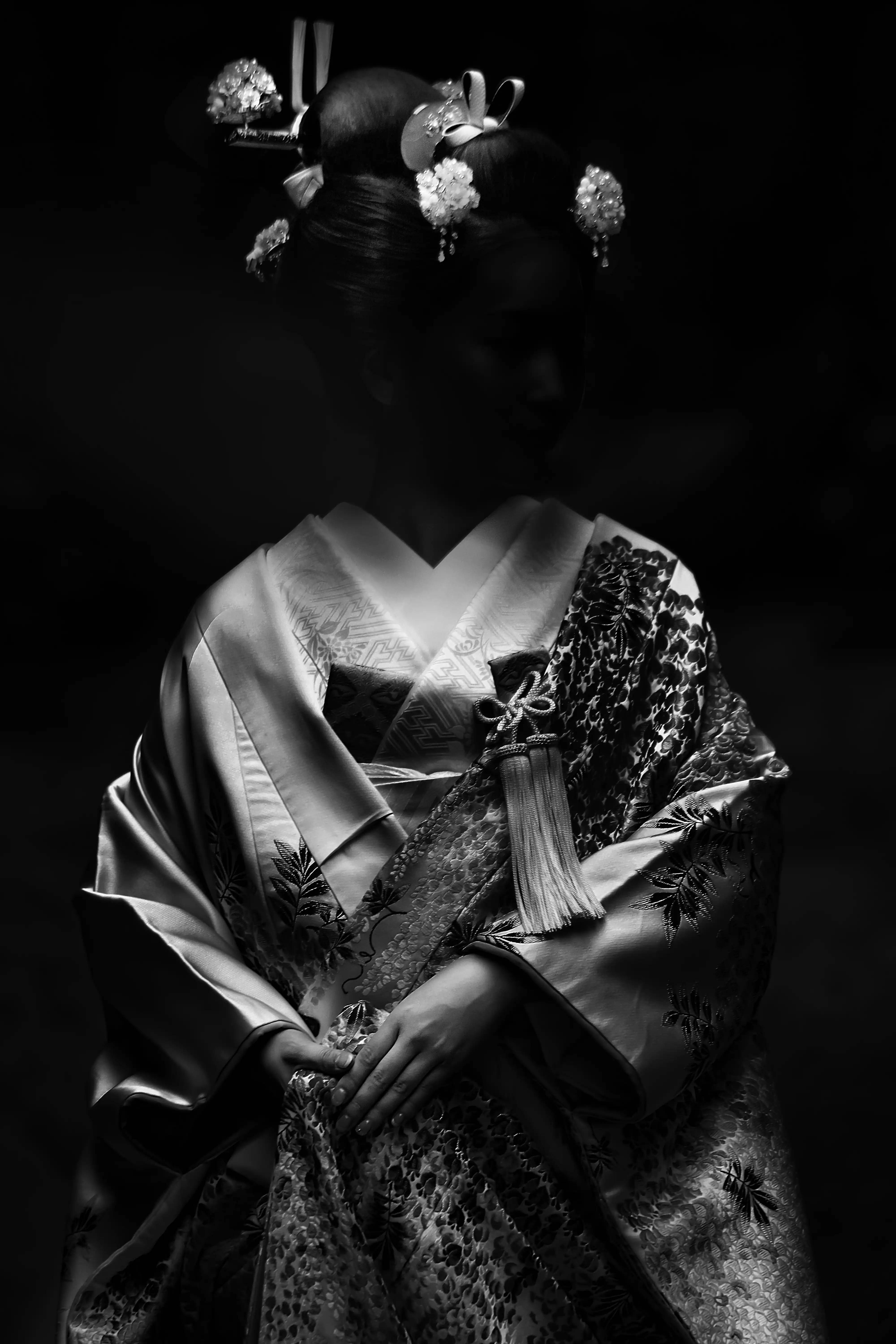 黑白 桌布 壁紙 — 一位身穿傳統日本和服、佩戴華麗髮簪的女性，站在戲劇性的黑白燈光下。