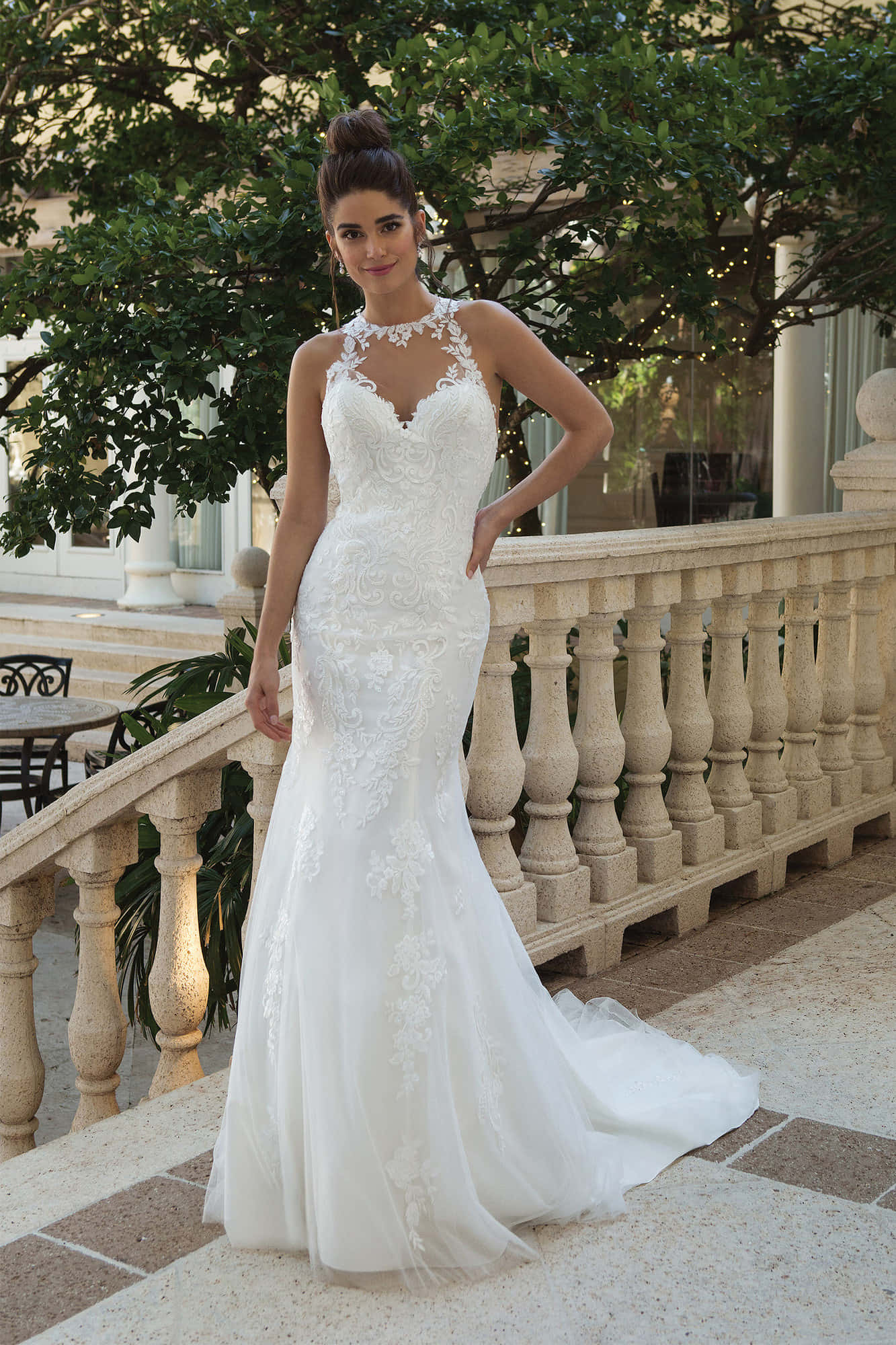 Wedding Dress 桌布 壁紙 — 一位身穿優雅白色蕾絲美人魚婚紗的女子，在綠意盎然的石造陽台上優雅地擺姿勢。