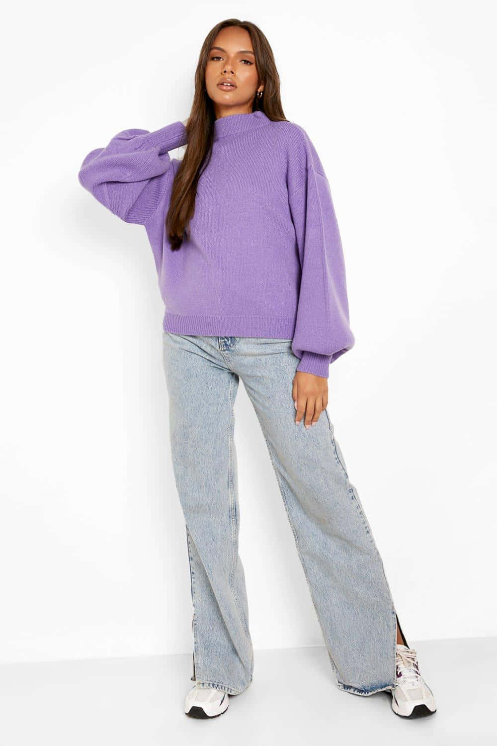 Purple Turtle-neck Sweater 桌布 壁紙 — 一位身穿寬鬆紫色毛衣和闊腳牛仔褲的女性在白色背景前擺姿勢。