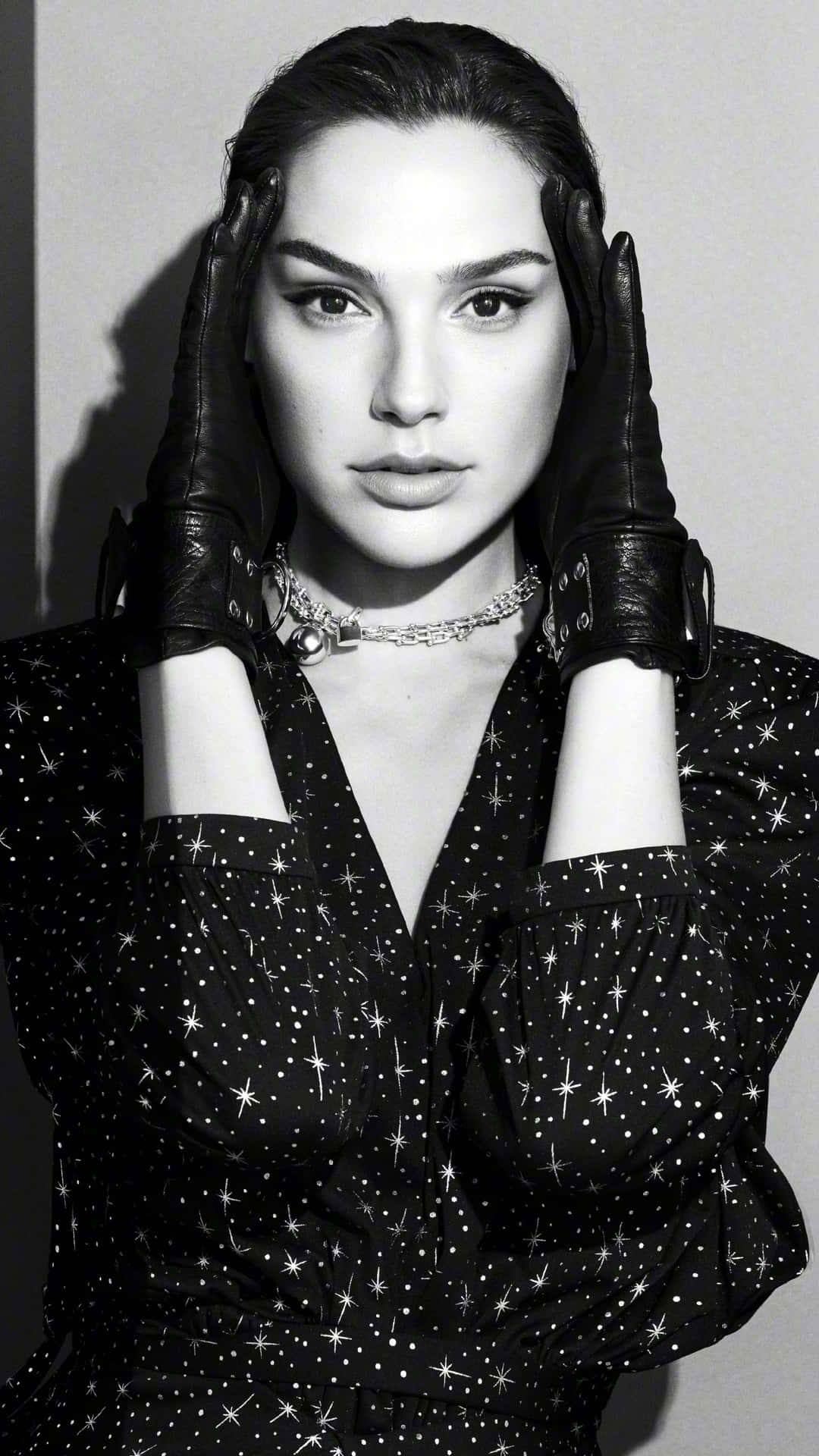 Black And White Celebrity 桌布 壁紙 — 一位身穿星星圖案服裝和皮手套的女性，雙手框著臉部擺姿勢的醒目黑白肖像。