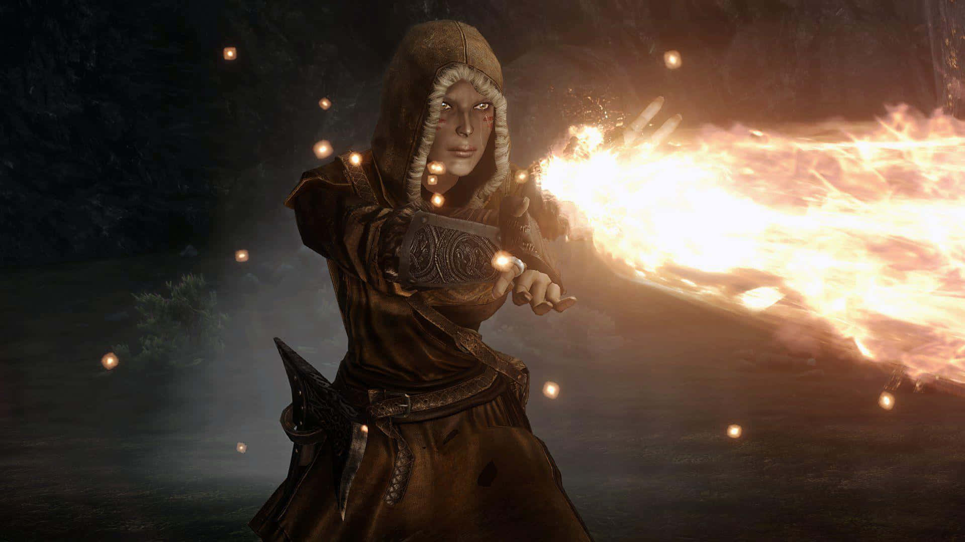 Skyrim Mage 桌布 壁紙 — 一位身穿棕色長袍的兜帽戰士在夜晚的黑暗森林中從手中釋放出火焰爆炸。