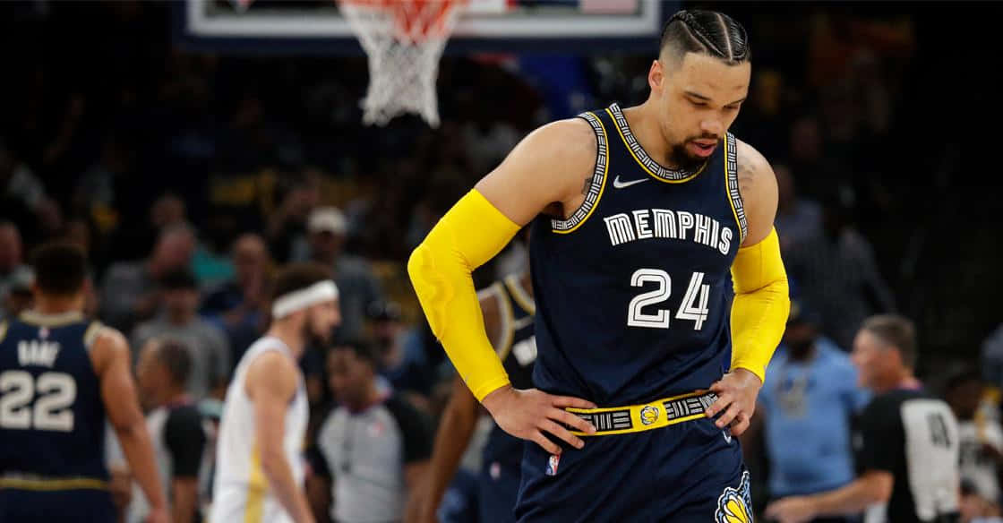 Dillon Brooks 桌布 壁紙 — 一位身穿海軍藍24號球衣的孟菲斯灰熊籃球運動員在比賽中，在場館燈光下雙手叉腰低頭站立。