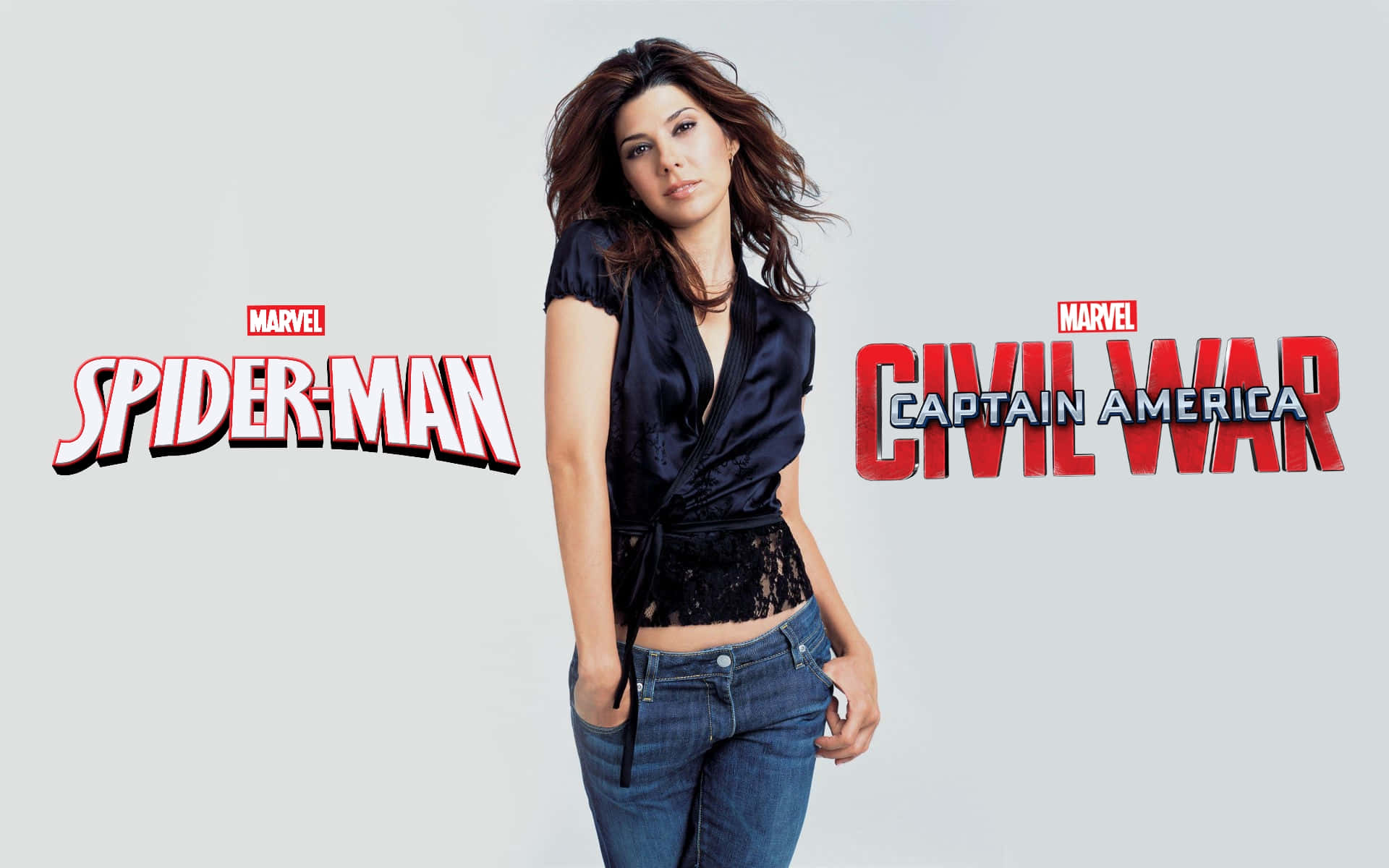 Aunt May 桌布 壁紙 — 一位身穿深色上衣和牛仔褲的女性站在蜘蛛俠與美國隊長：英雄內戰電影標誌之間，背景為純灰色。