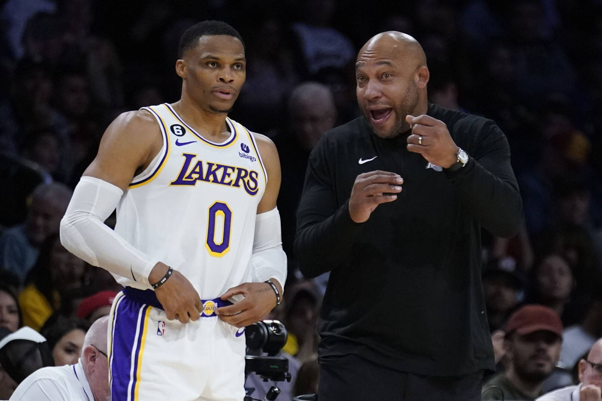 NBA 桌布 壁紙 — 一位身穿湖人隊球衣的籃球運動員站在一位在比賽中激情比劃的動畫教練旁邊。