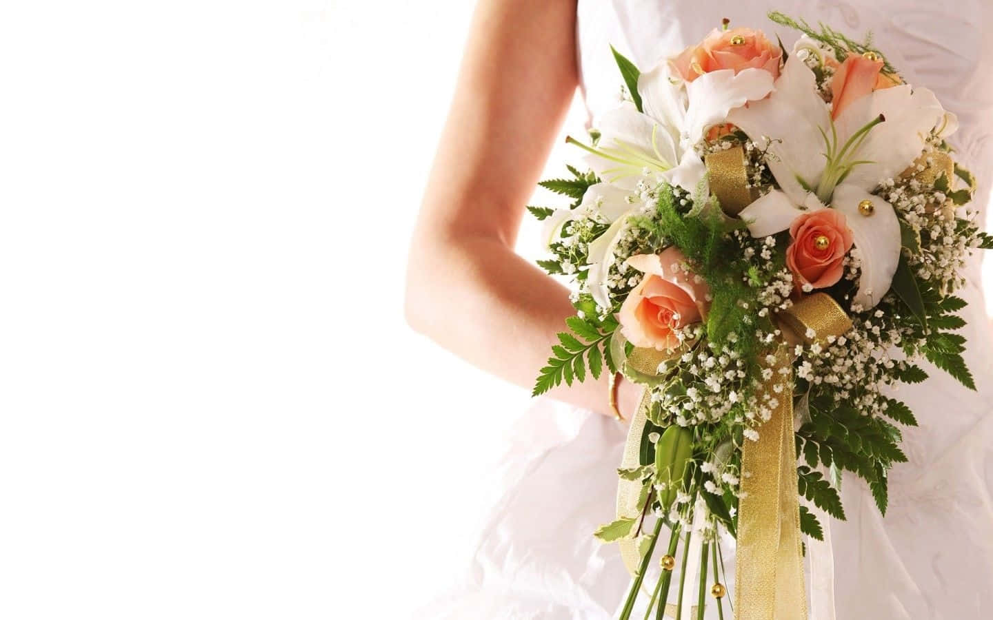 Wedding Flowers 桌布 壁紙 — 一位身穿白色婚紗的新娘，手持一束由白色百合、蜜桃玫瑰和綠葉組成，並以金色絲帶捆綁的豐盛花束，背景是明亮的白色。