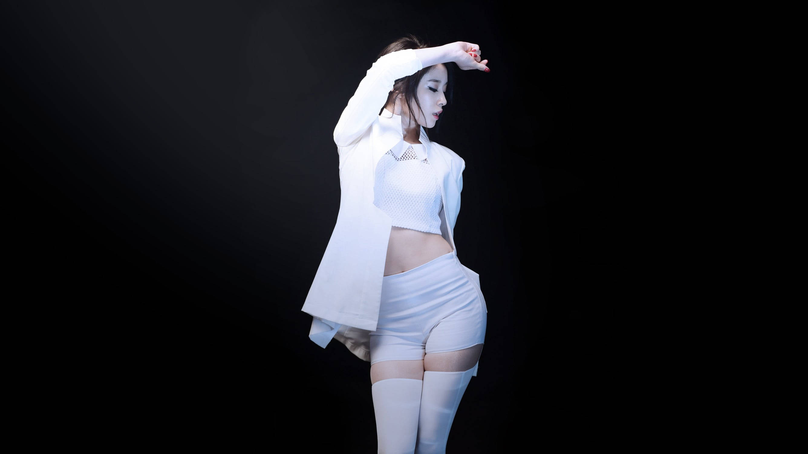 女孩 桌布 壁紙 — 一位身穿白色服裝的女性在純黑背景下，以戲劇性燈光優雅地擺姿勢。
