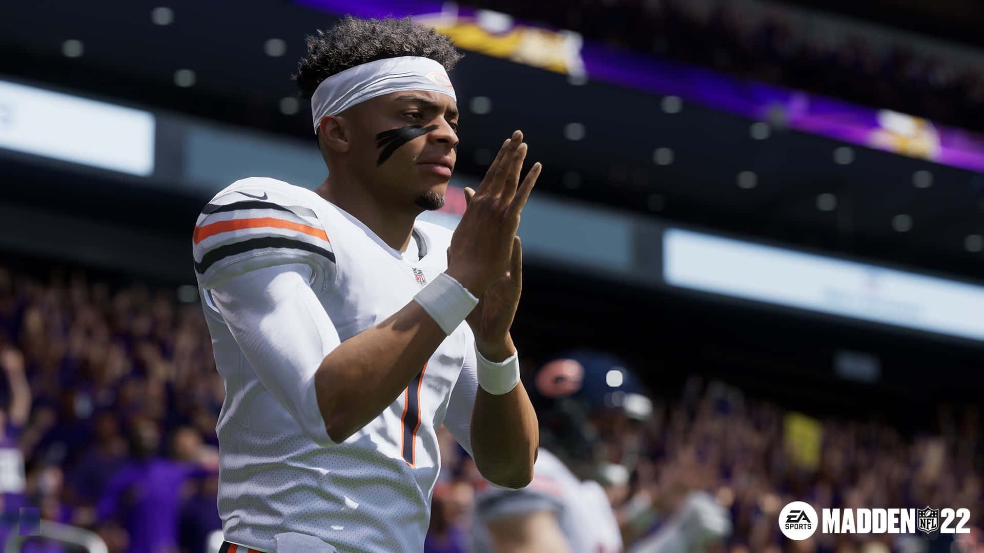Madden NFL 22 桌布 壁紙 — 一位身穿白色球衣的美式足球四分衛在明亮的日光下，於一個充滿歡呼球迷的體育館中拍手。