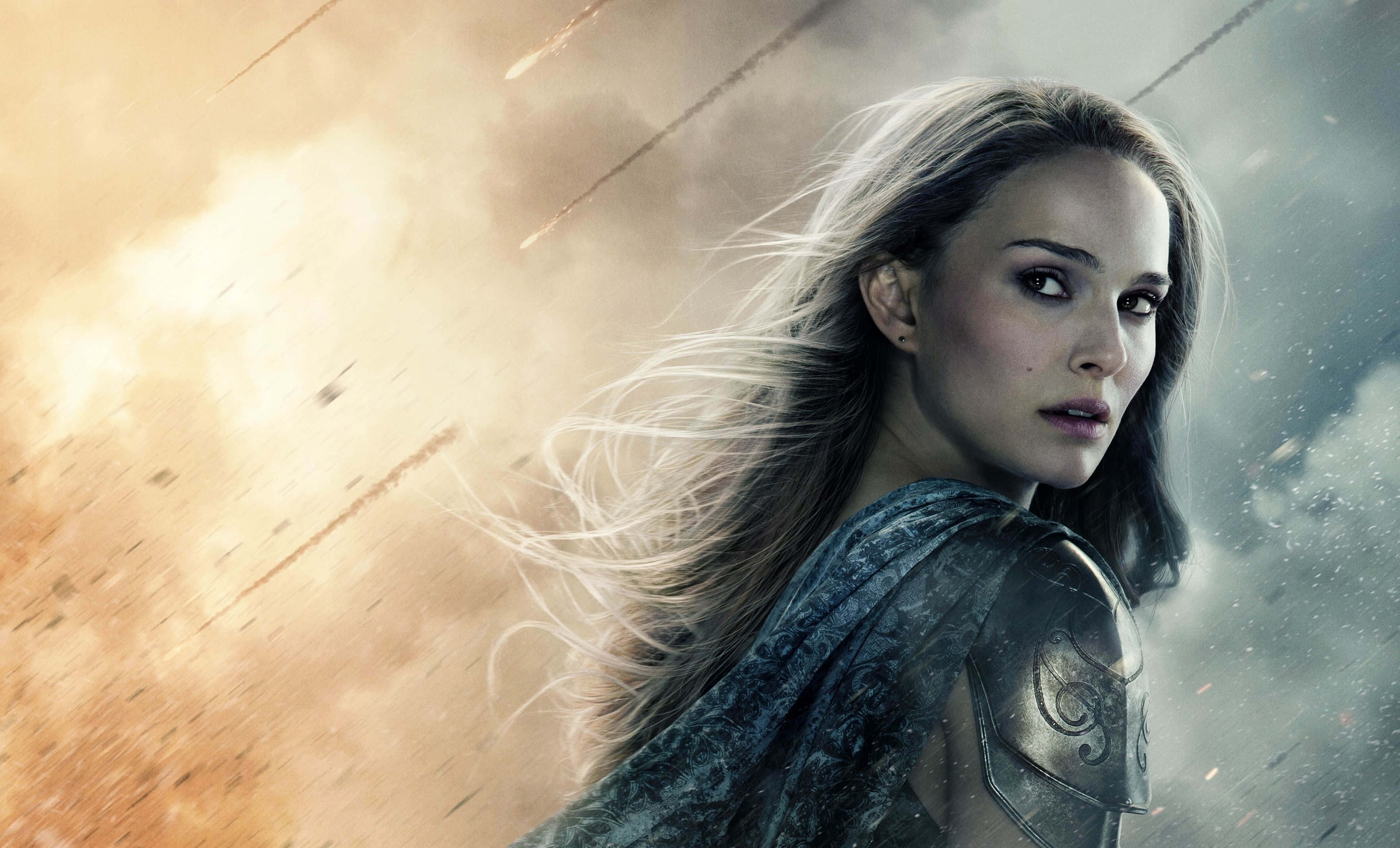 Jane Foster 桌布 壁紙 — 一位身穿盔甲的女戰士凝視前方，爆炸和碎片在她身後飛舞，形成混亂的戰鬥場景。